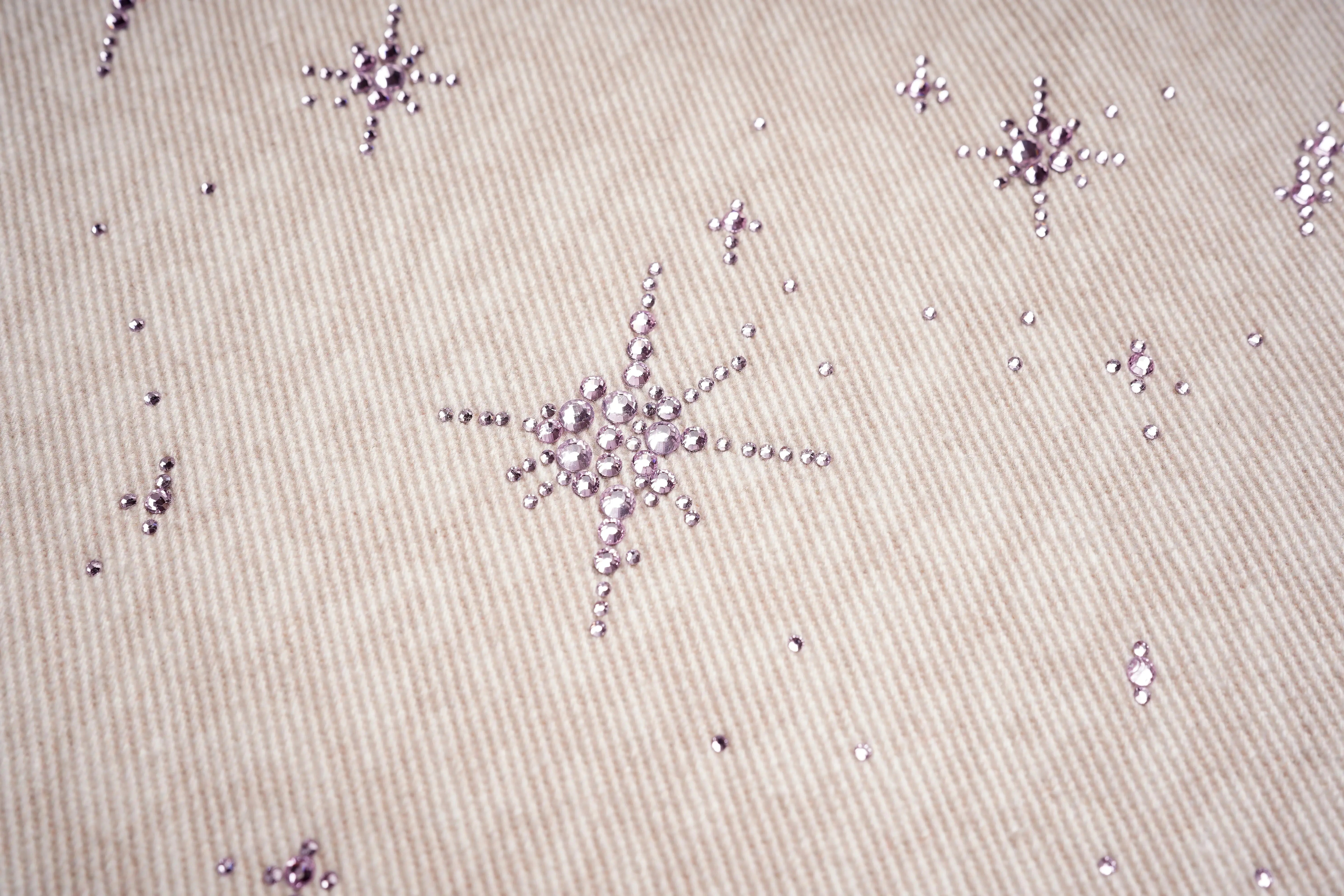 Close-up of decorative star patterns on a beige fabric background, TCH Rhinestone Star & Angel Wings Beige Denim Jeans
