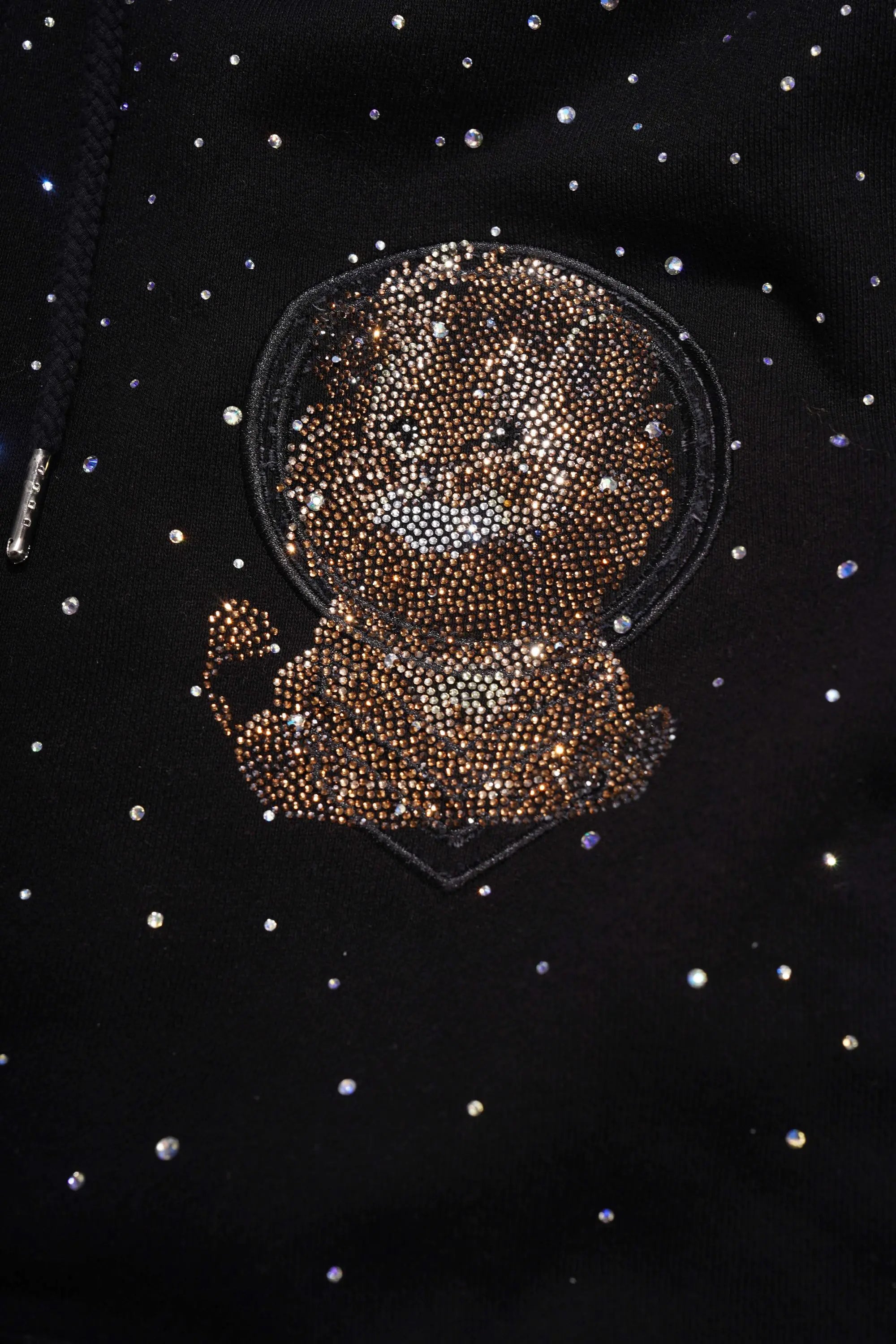 Black jacket with a rhinestone crab patch on a dark background. TCH Rhinestone Starry Sky Lion Hoodie