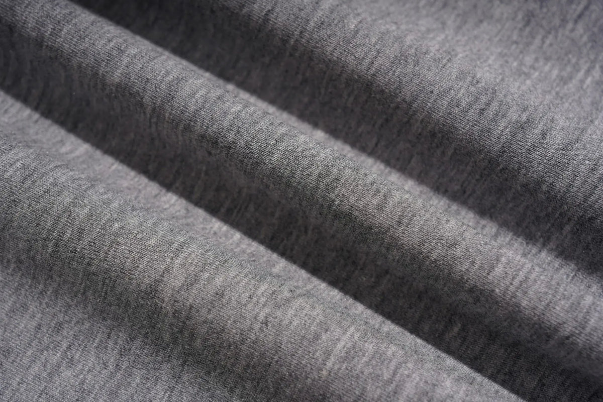 Close-up of draped heather gray fabric with soft folds and visible knit texture. TCH Rhinestone Techno Unicorn Graphic T-Shirt