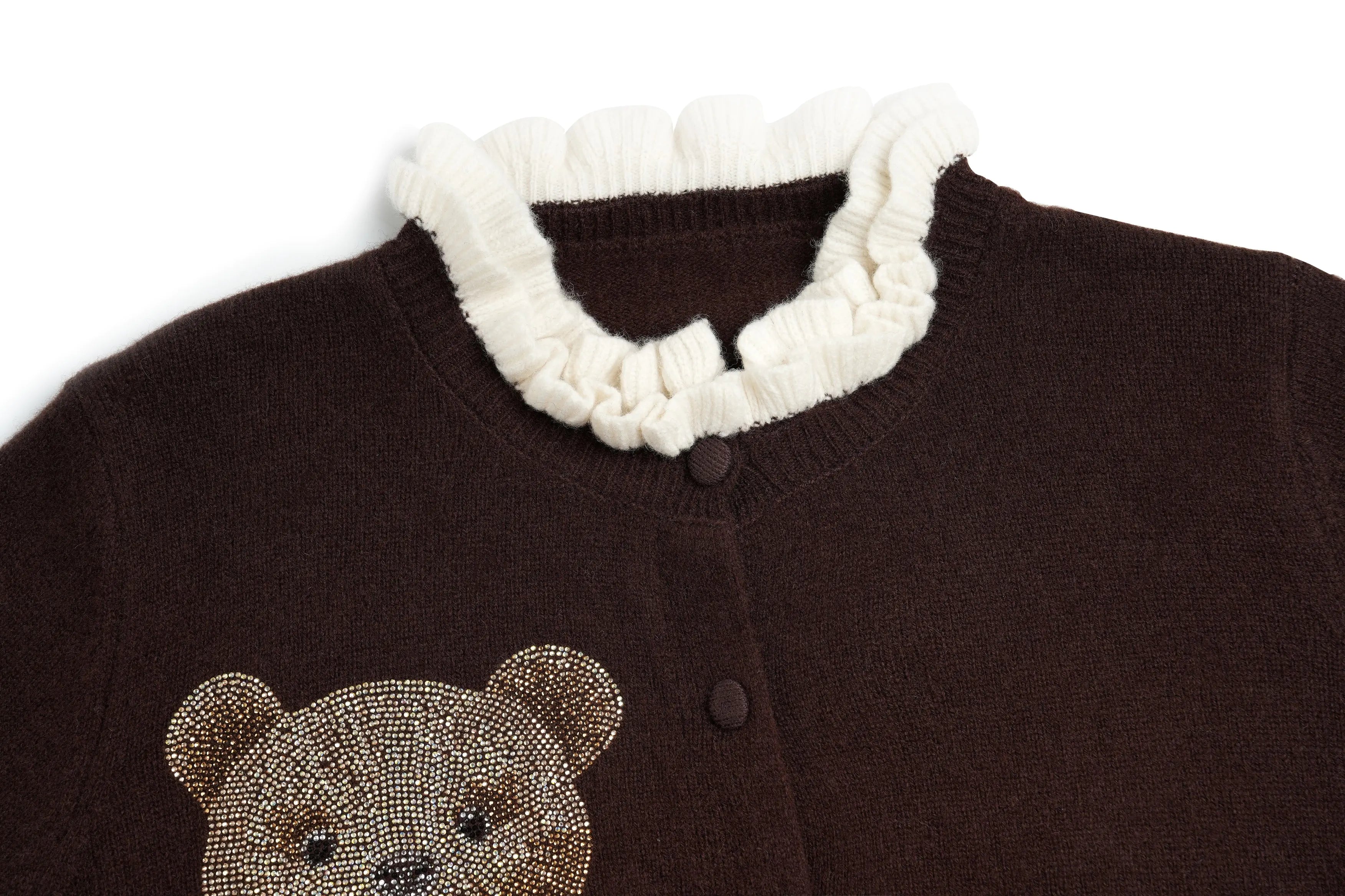 A close-up of a dark brown knit cardigan featuring a cream-colored ruffled collar and a teddy bear face embellished with rhinestones on the front. TCH Rhinestone Teddy Bear Bow Ruffle Knit Cardigan