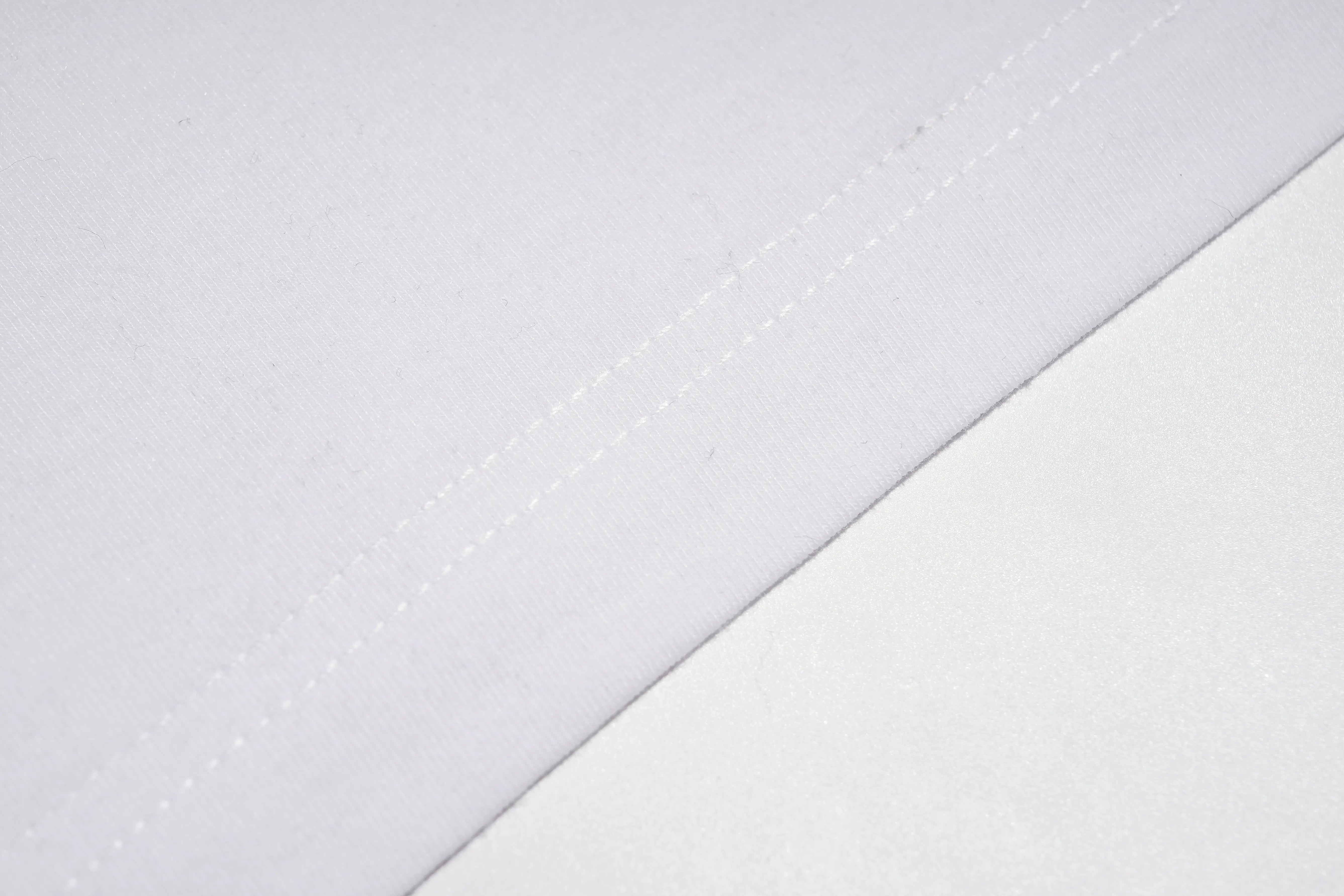 A close-up of white fabric with a diagonal fold and visible double-stitched seam detail. TCH Rhinestone Teddy Bear Graphic White T-Shirt