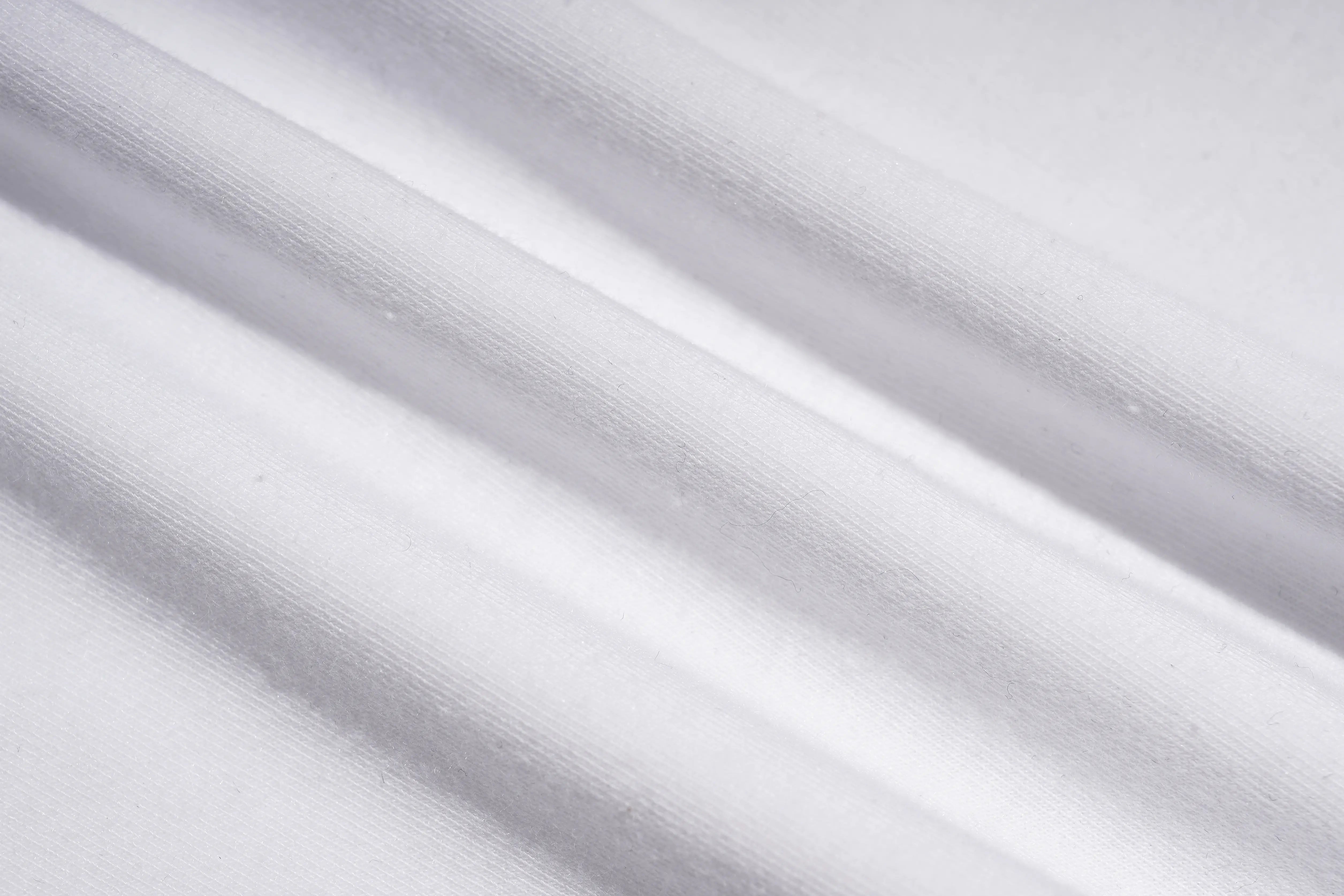 A close-up of white fabric with soft diagonal folds and a smooth texture. TCH Rhinestone Teddy Bear Graphic White T-Shirt