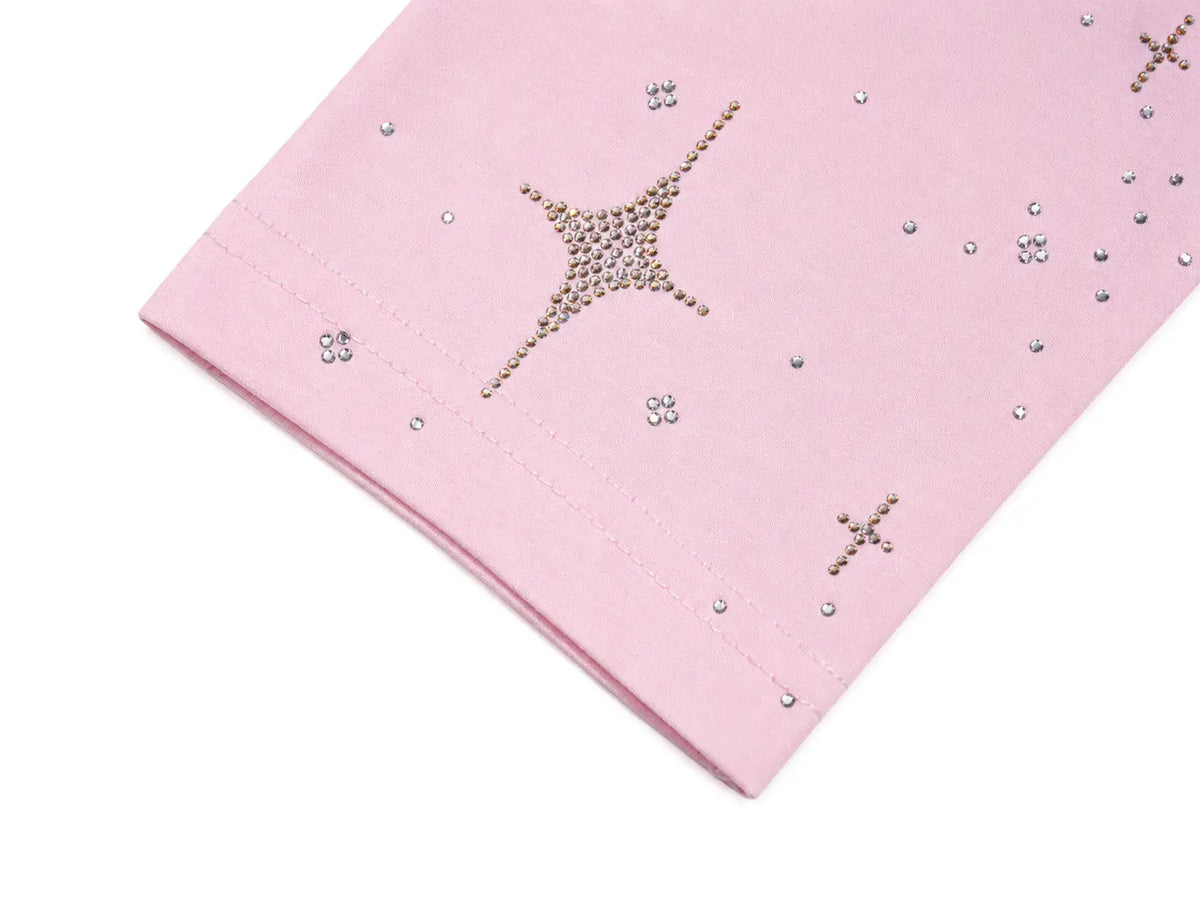A close-up of a light pink fabric item, likely a garment or textile panel, decorated with rhinestone star and cross motifs on a white background. TCH Rhinestone Teddy Bear Pink Long Sleeve T-Shirt