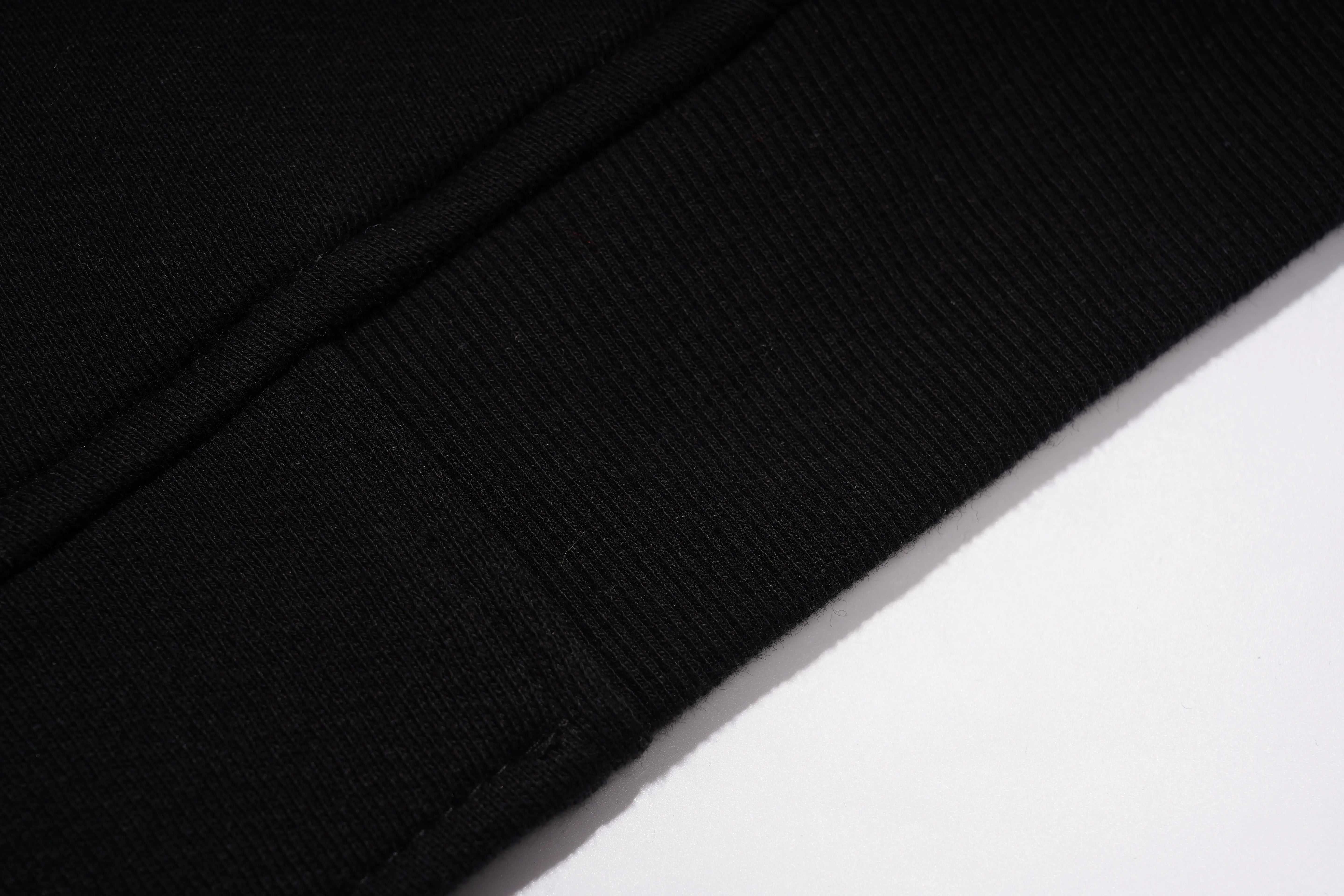 Close-up of a black textured fabric on a white background, TCH Rhinestone Teddy Bear Wing Sleeve Bomber Jacket