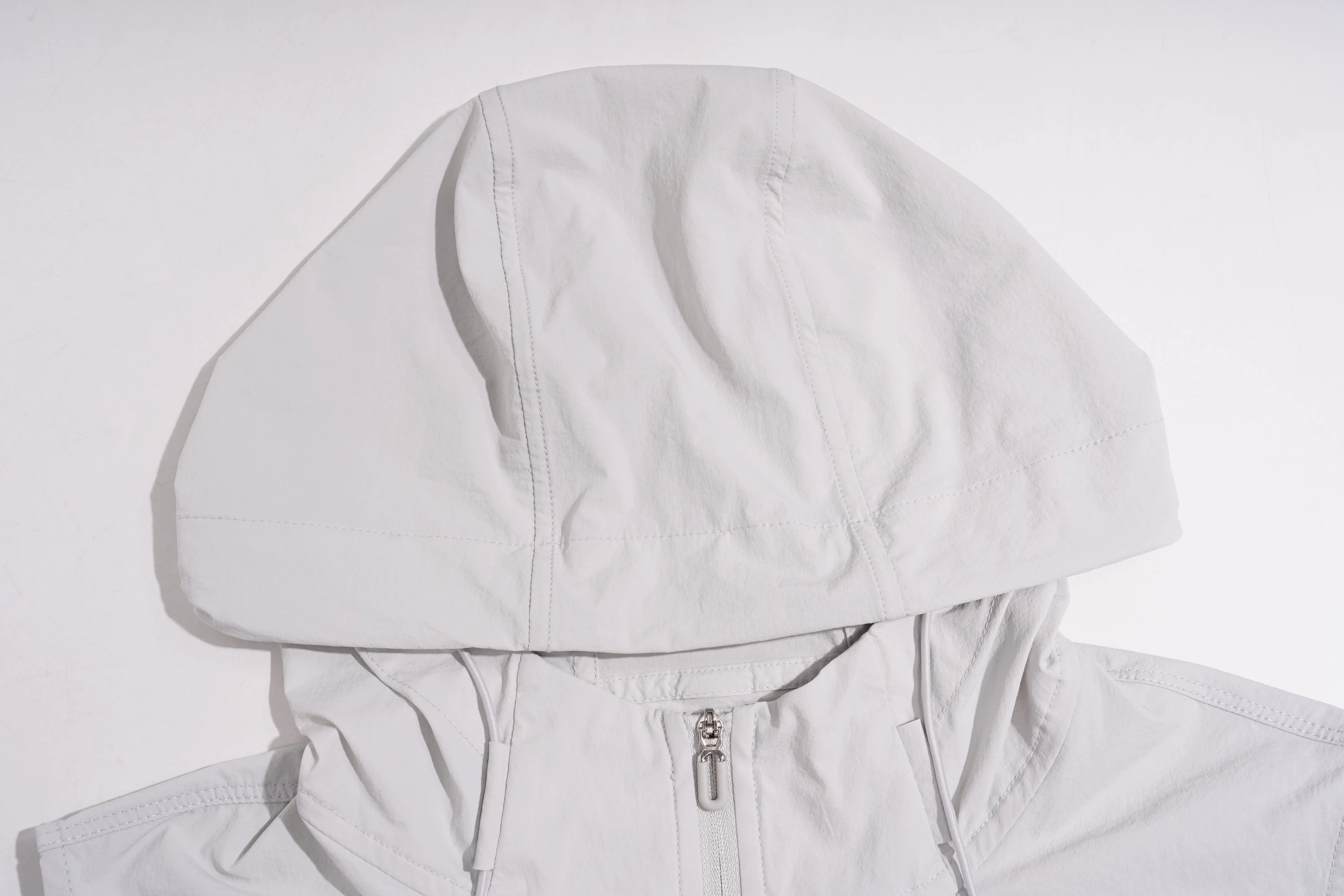 A close-up of a light gray hooded jacket with a front zipper, laid flat against a white background. TCH Rhinestone Wing Active 3-Piece Tracksuit Set