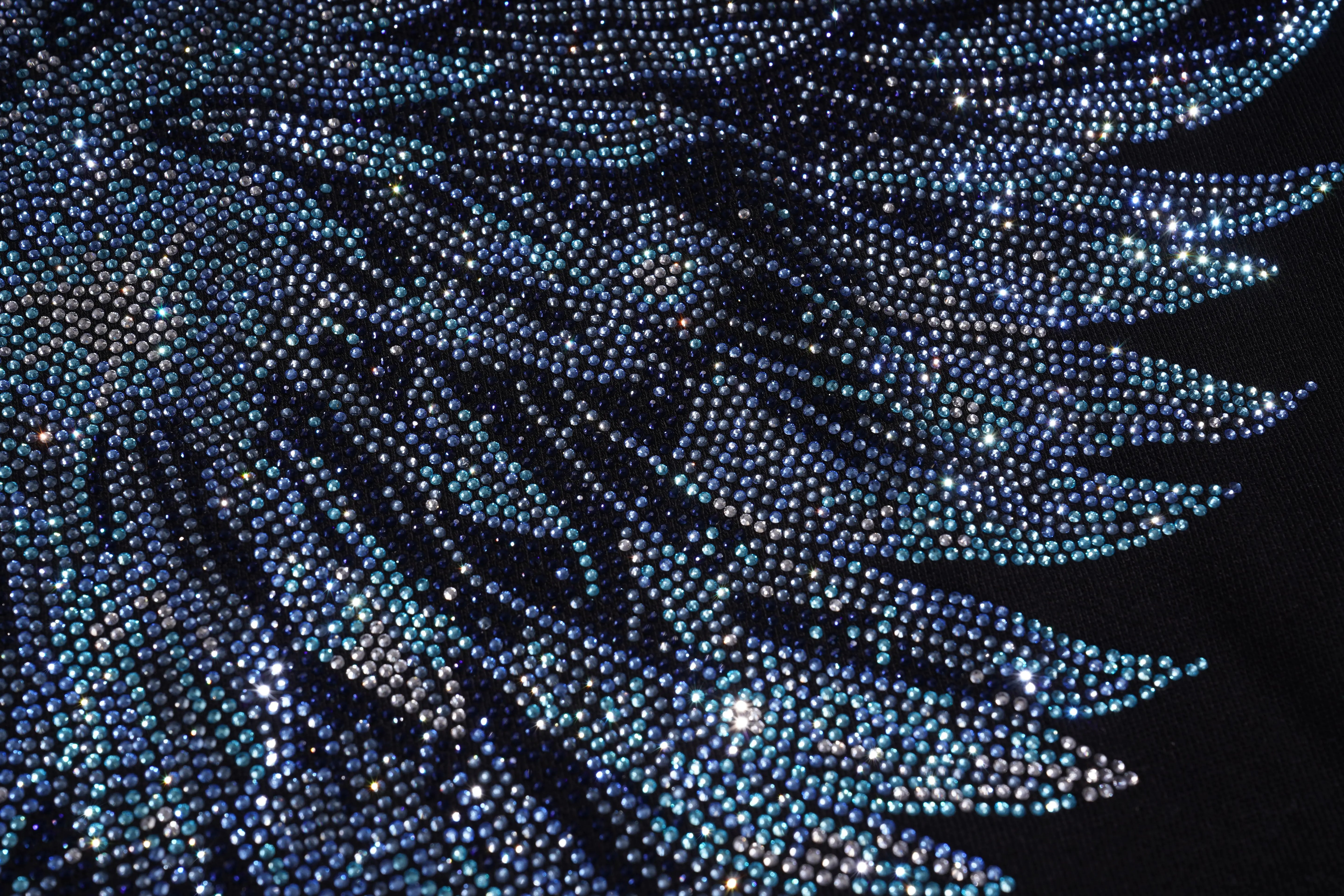 Close-up of a sparkling blue feather-like pattern on a black background, TCH Rhinestone Wing Black Crewneck Sweatshirt
