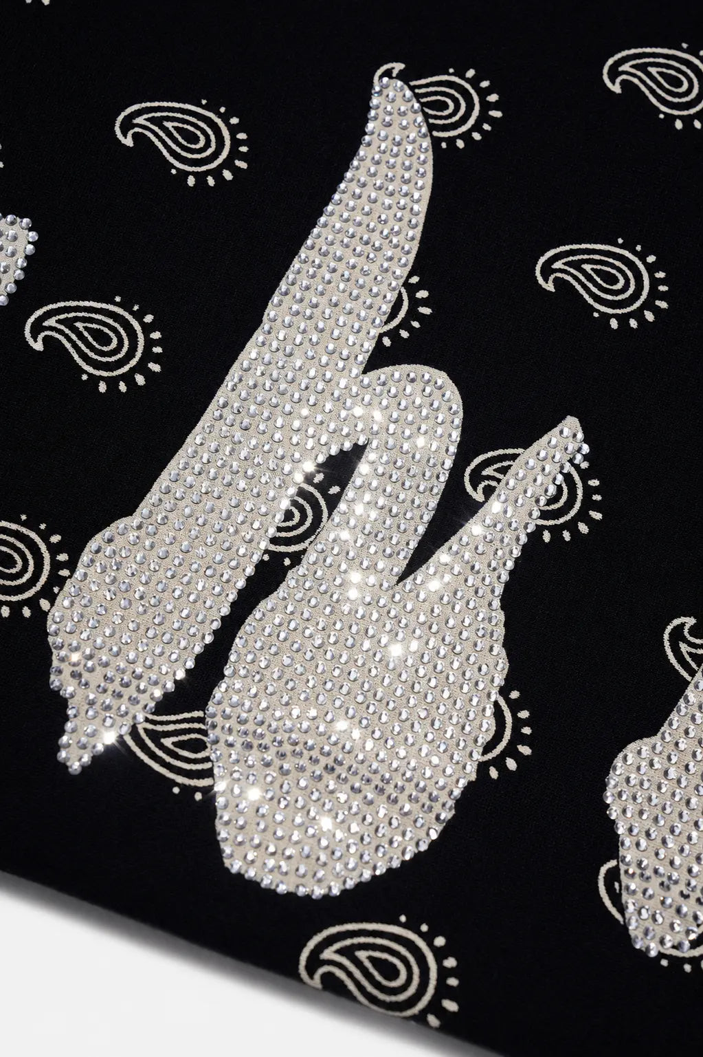 A close-up of a black fabric featuring large silver paisley motifs and small matching paisley prints, embellished with sparkling rhinestones. TCH Rhinestone Wing Paisley Wide-Leg Sweatpants