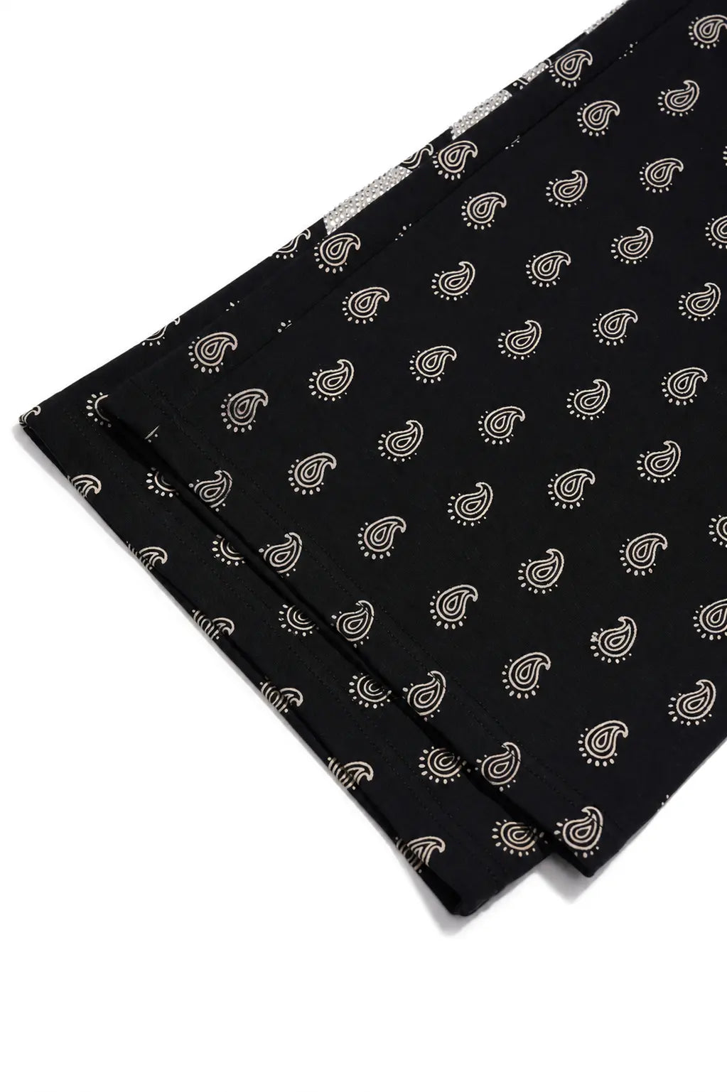 Black fabric with a repeating beige paisley pattern, folded diagonally on a white background. TCH Rhinestone Wing Paisley Wide-Leg Sweatpants
