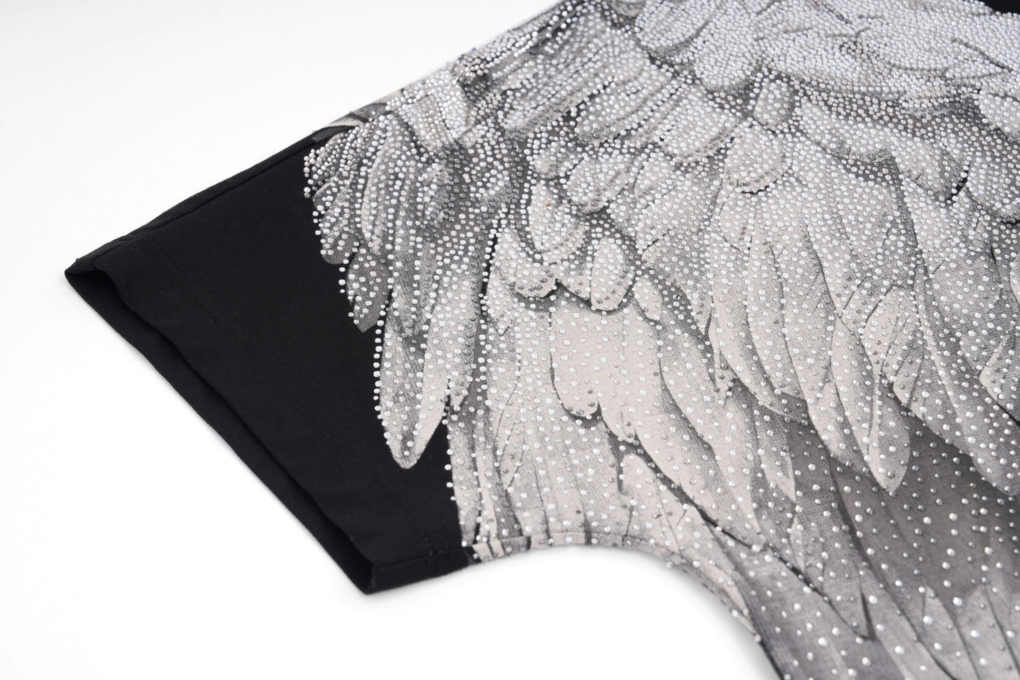 Close-up of a black garment with floral embroidery on a white background, TCH Rhinestone Wings Logo Black Graphic T-Shirt