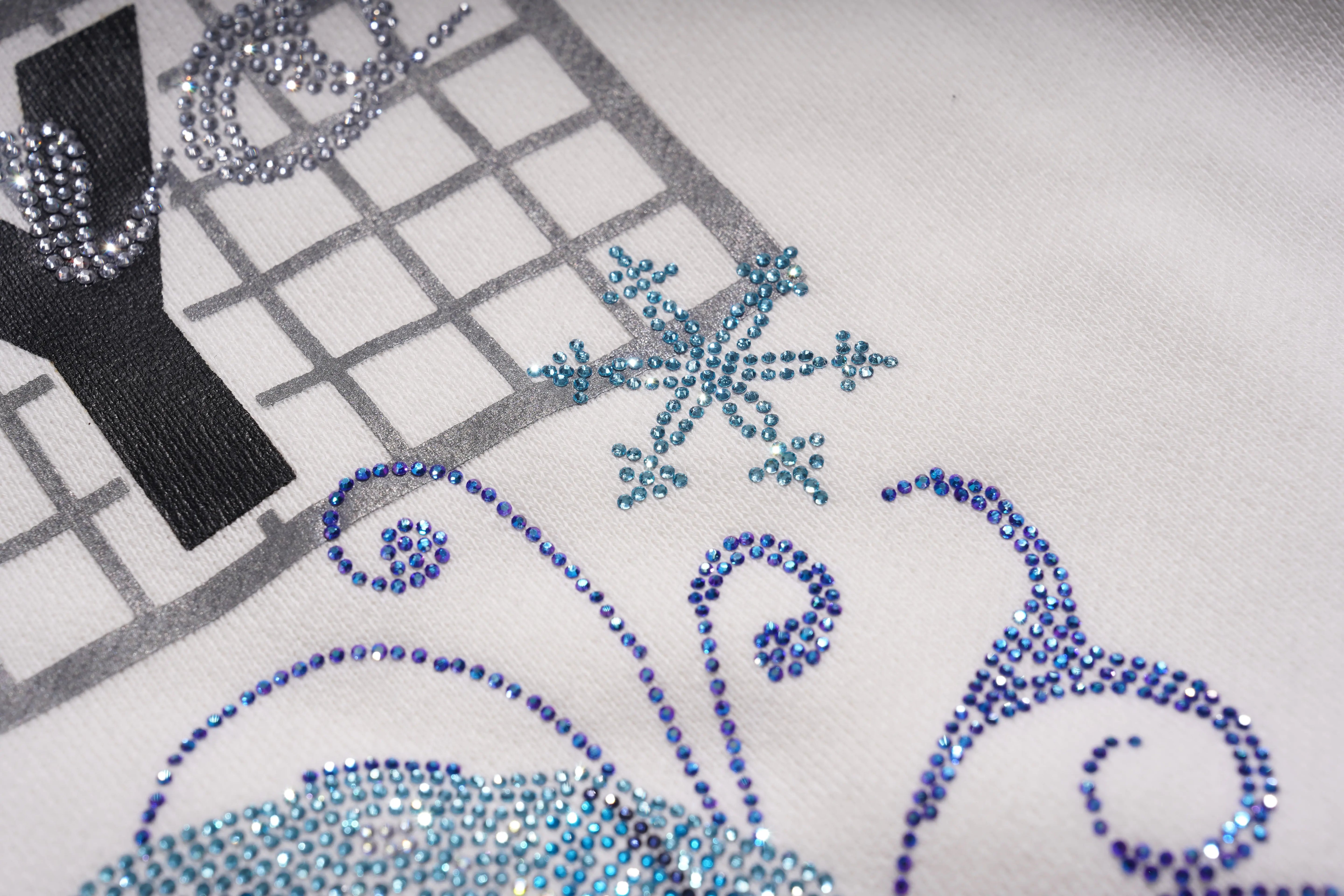 Close-up of a decorative design with rhinestones on a fabric background, TCH Rhinestone Winter Lamb Sweatshirt