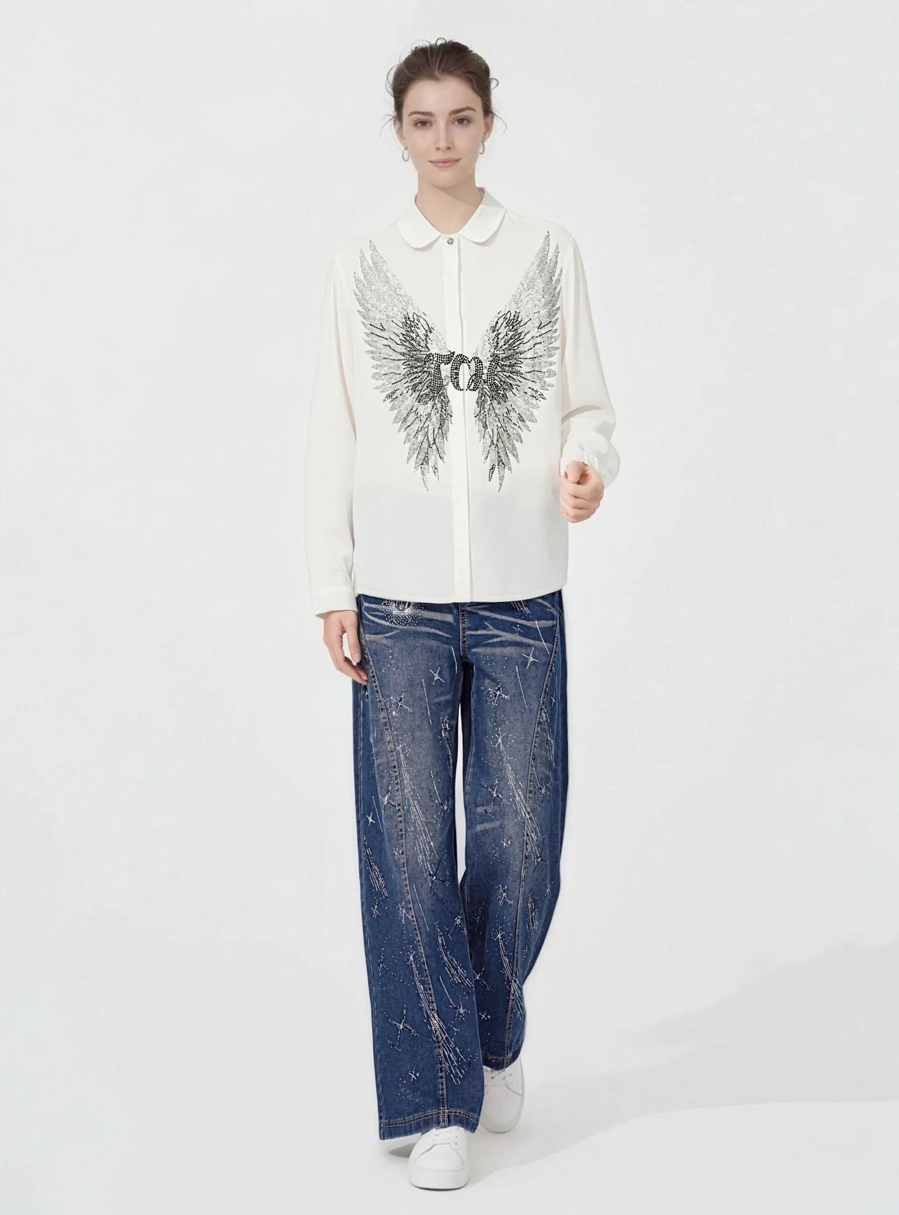Person wearing a white blouse with a decorative design and blue jeans on a white background, TCH Shooting Star Rhinestone Wide-Leg Blue Jeans