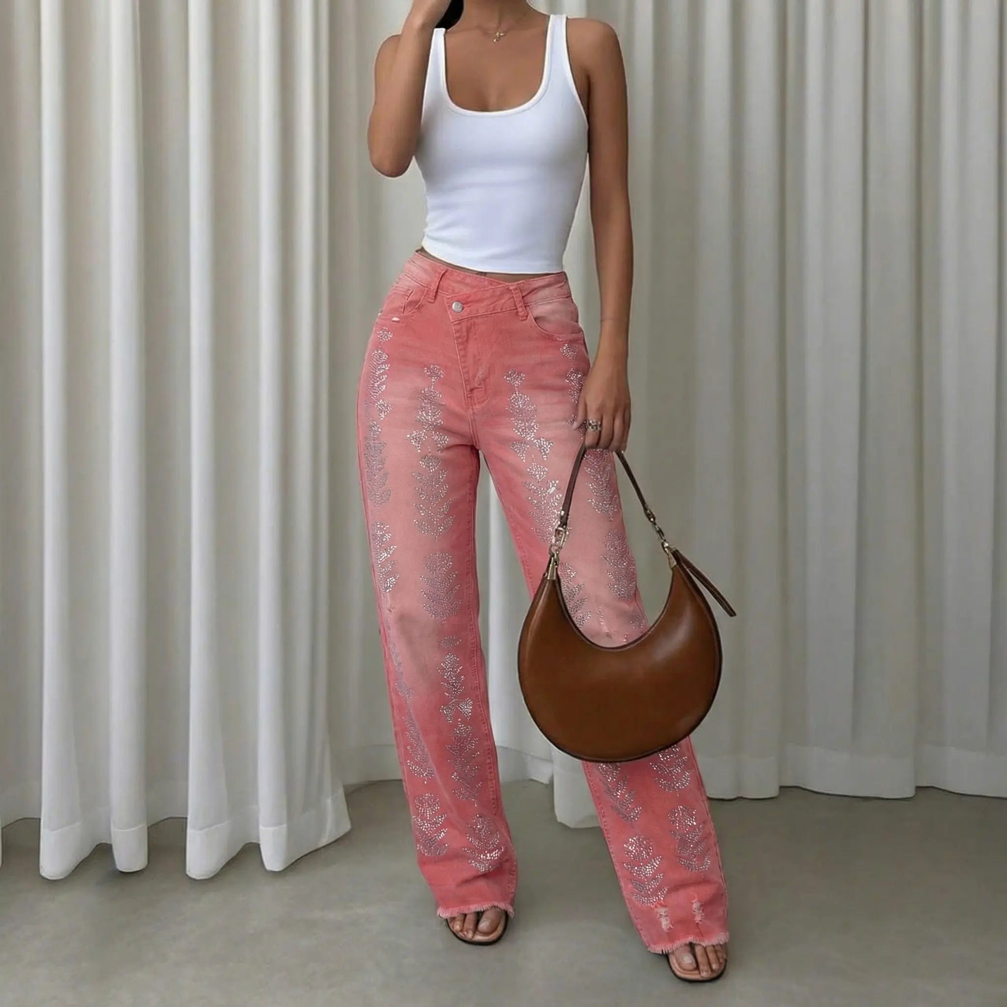 Person wearing a white tank top and pink pants holding a brown bag against a white curtain background, TCH Silver Bouquet Rhinestone Pink Denim Jeans
