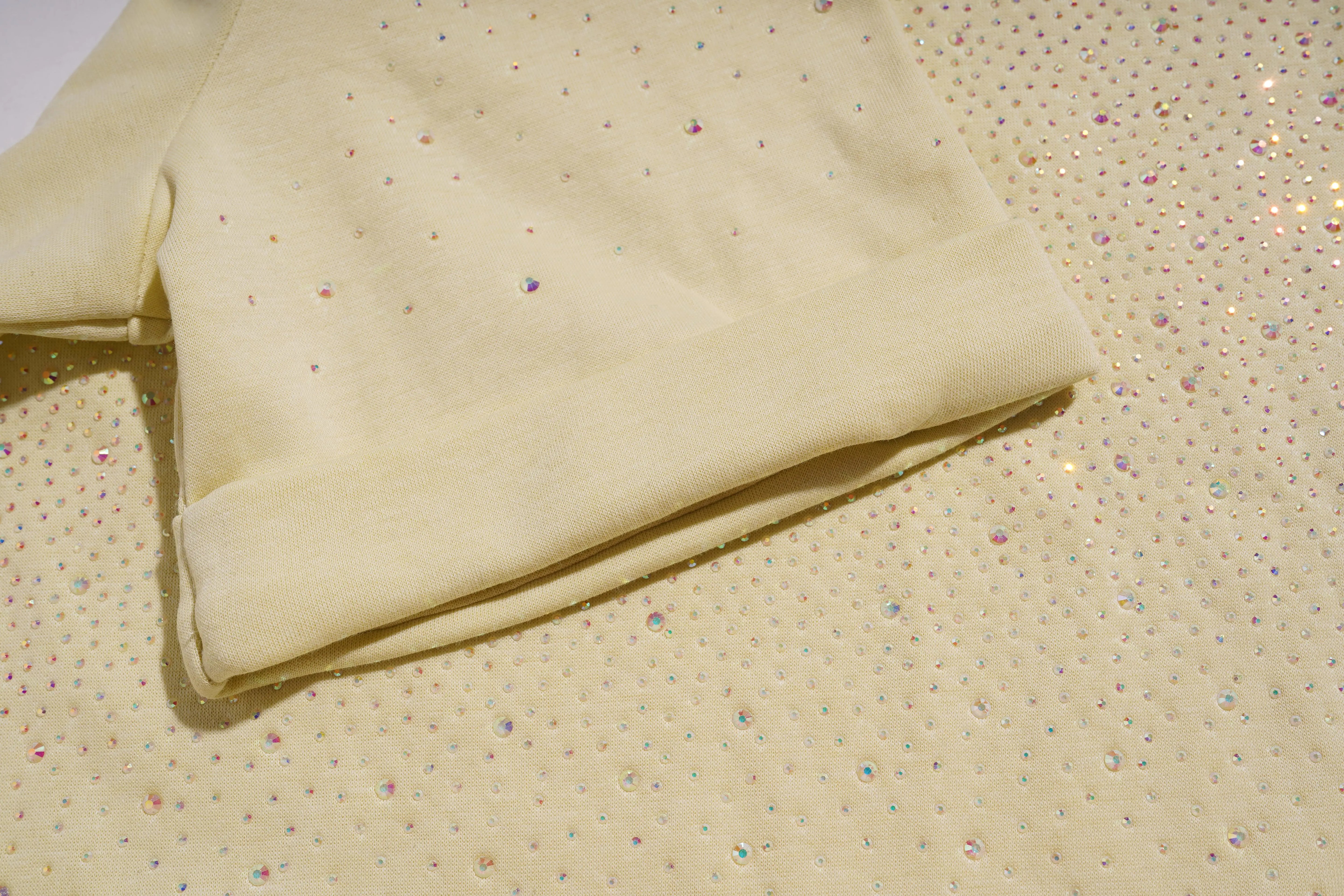 Folded beige fabric on a textured beige surface, TCH Starry Gradient Rhinestone Butterfly T-Shirt