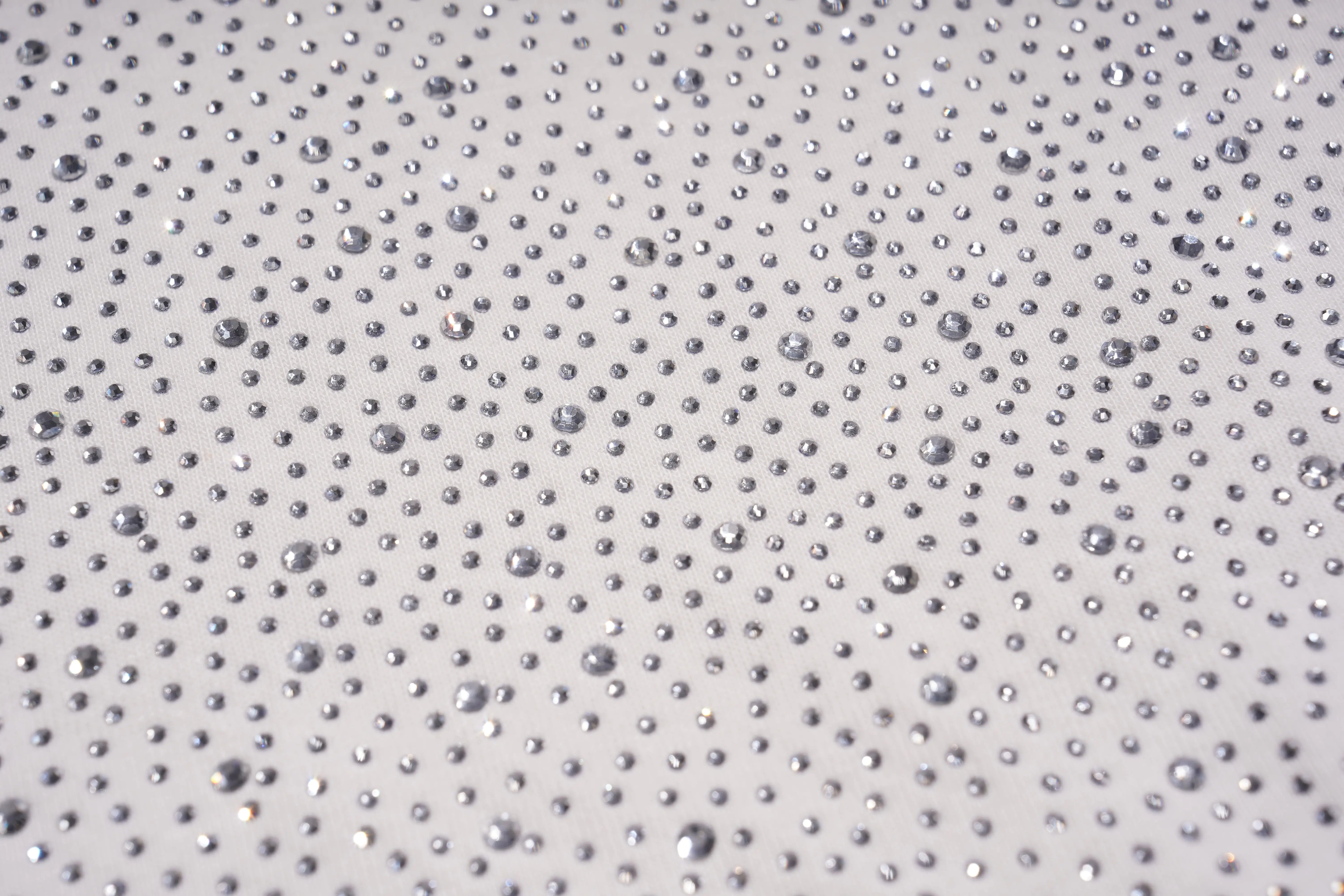 Close-up of a textured surface with small raised dots on a light gray background, TCH Starry Gradient Rhinestone Butterfly T-Shirt