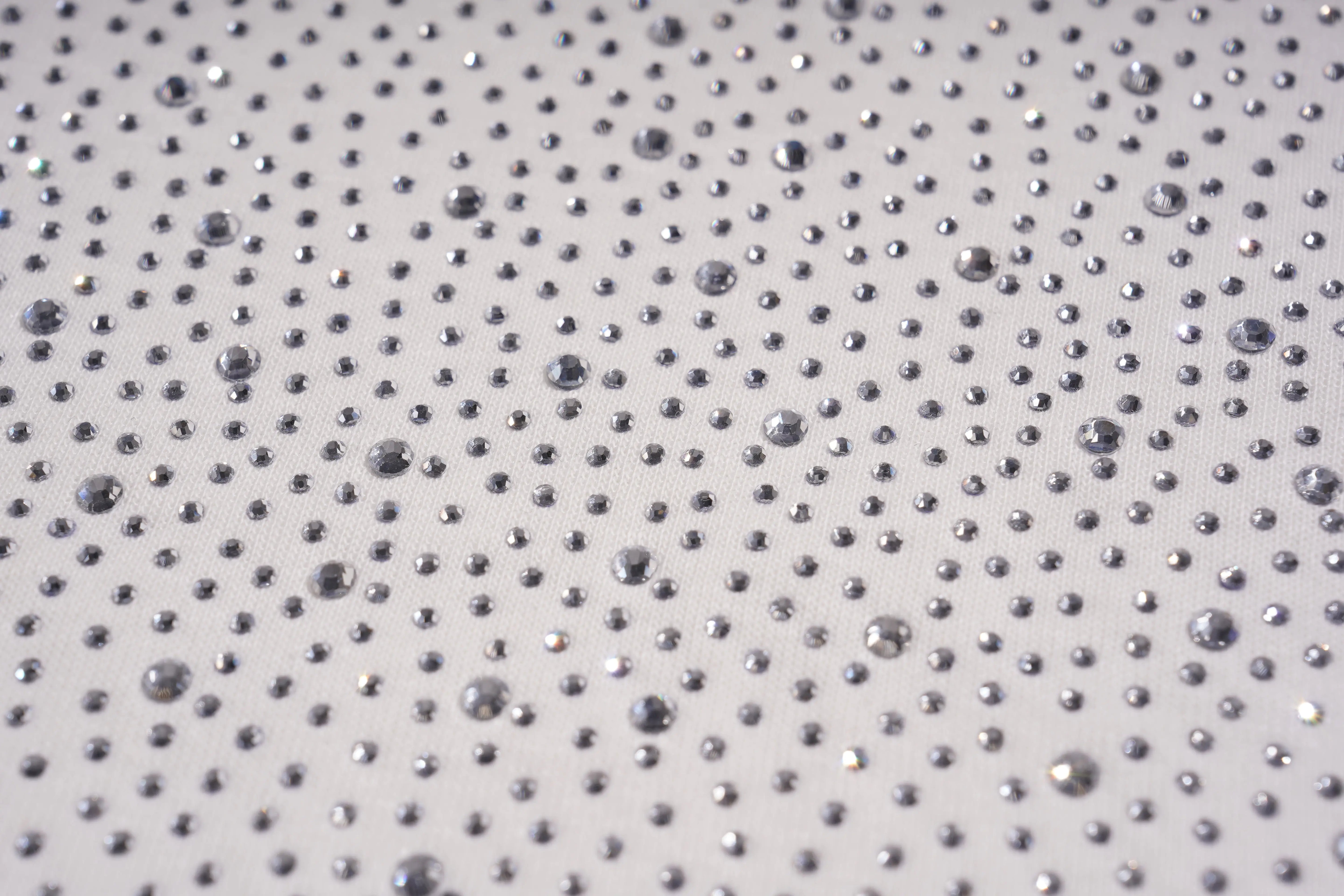 Close-up of a textured surface with small raised dots on a light gray background, TCH Starry Gradient Rhinestone Butterfly T-Shirt
