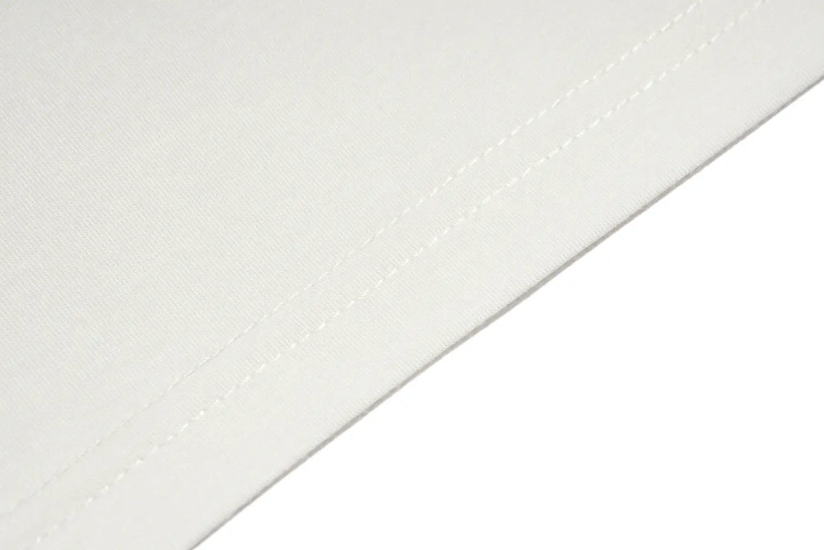 Close-up of a white fabric surface with visible diagonal stitching along a folded edge on a white background. TCH Sweet Bunny Rhinestone Graphic Long Sleeve Top