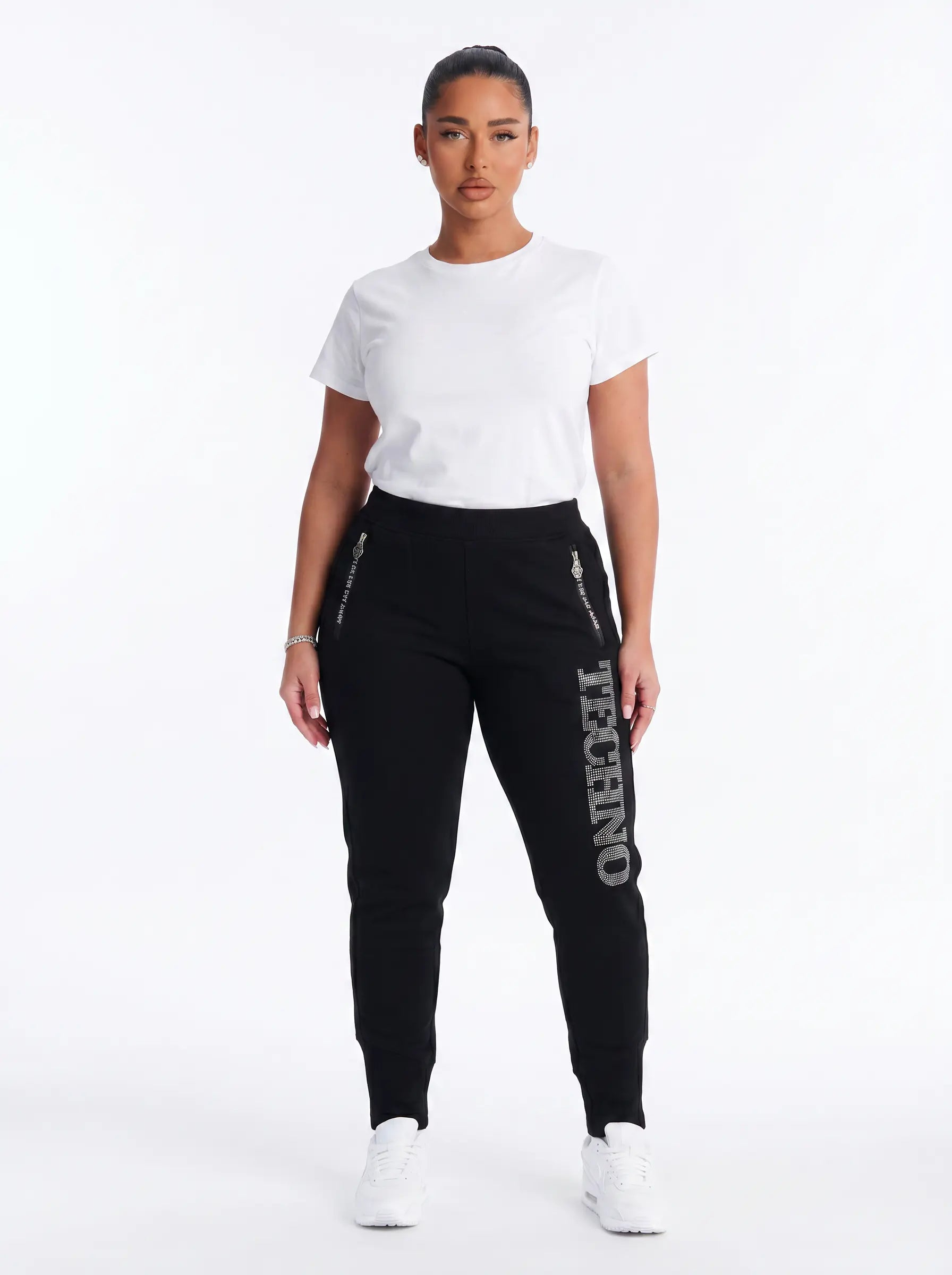 Woman wearing a white t-shirt and black jogger pants with 'TECHNO' text on a white background, TCH TECHNO Rhinestone Jogger Pants