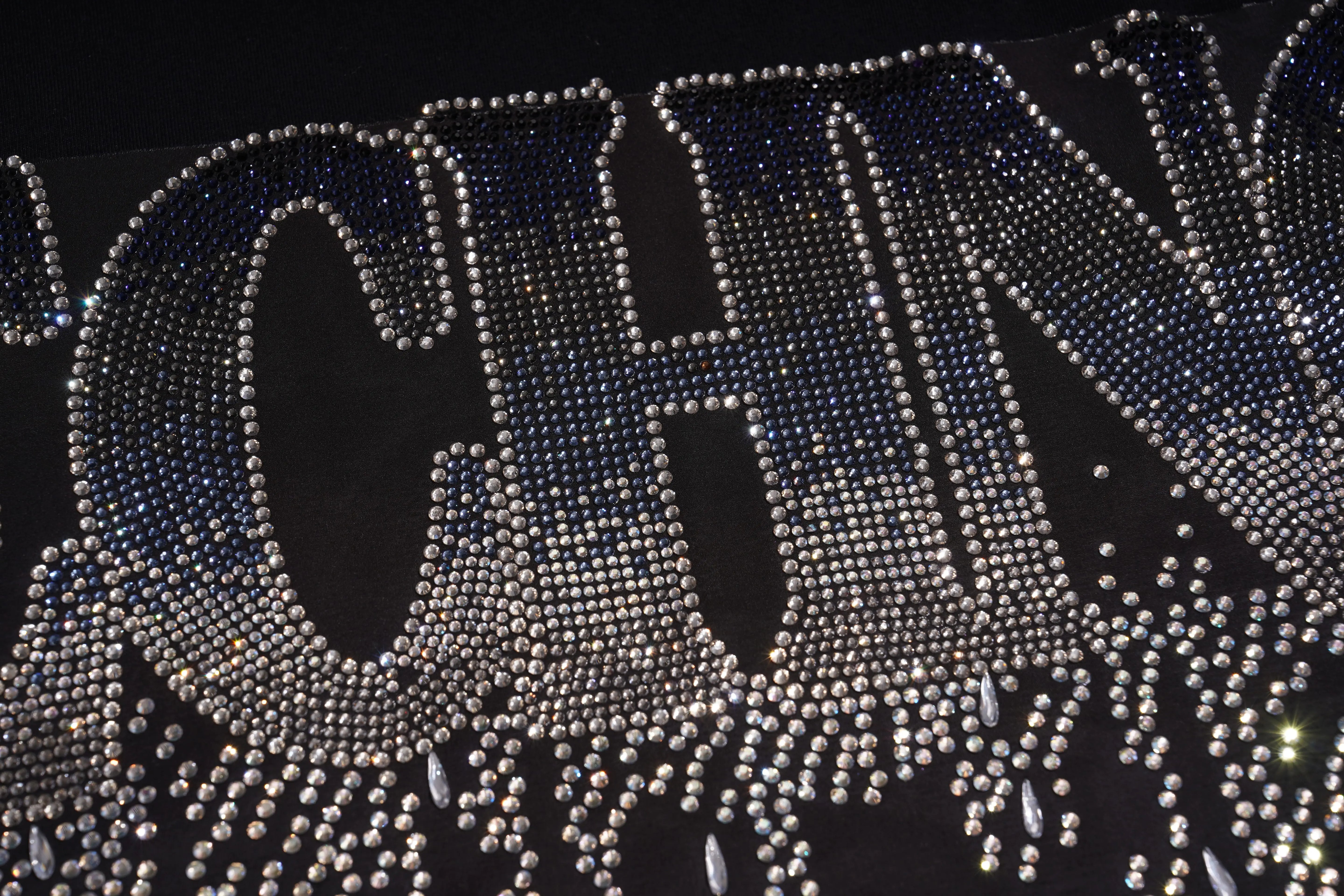 Close-up of a rhinestone-embellished 'CHANEL' logo on a black background, TCH TECHNO Waterfall Rhinestone T-Shirt