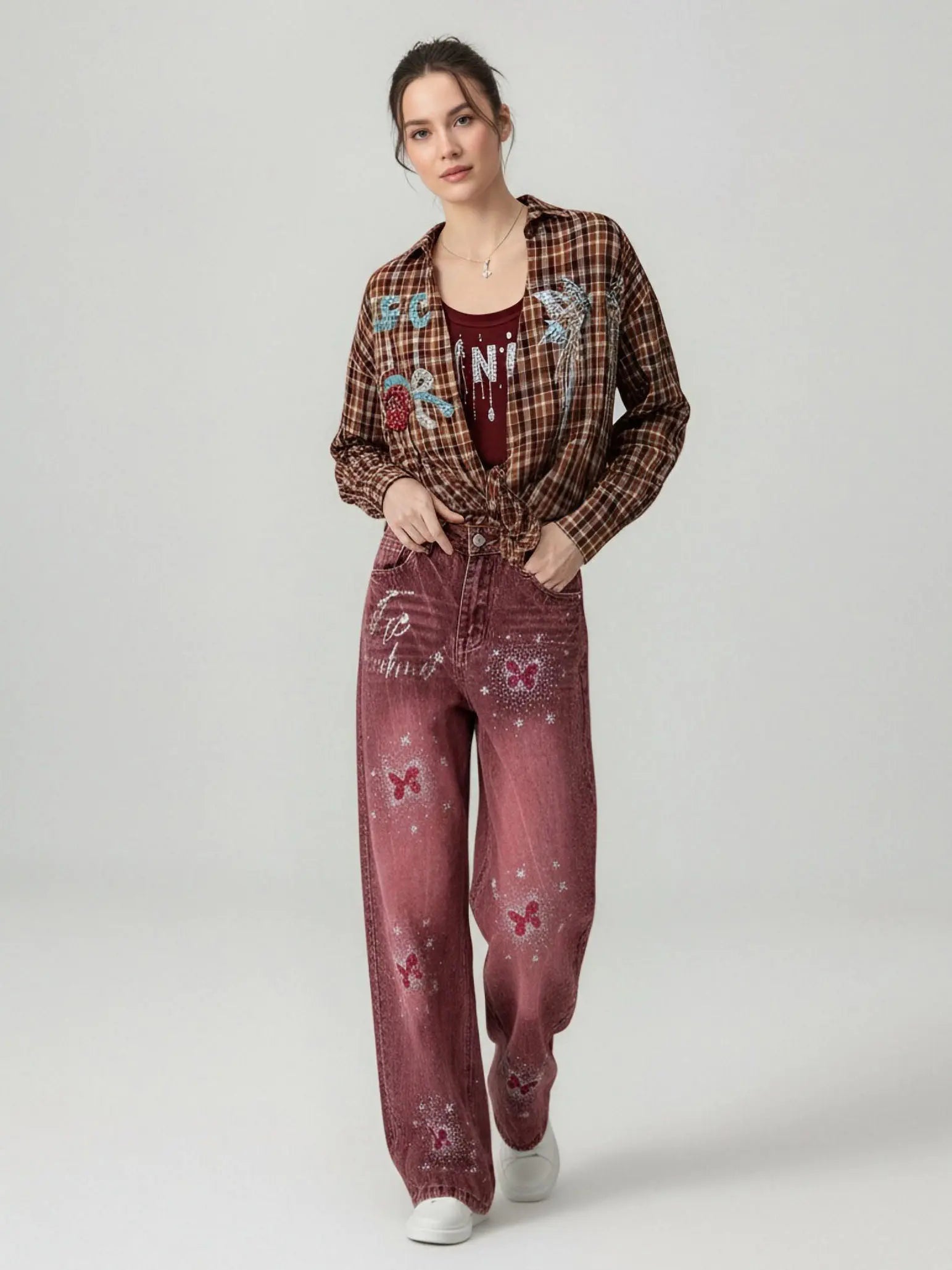 Woman wearing a plaid shirt and red jeans with butterfly designs on a white background, TCH Techno Butterfly Rhinestone Burgundy Jeans