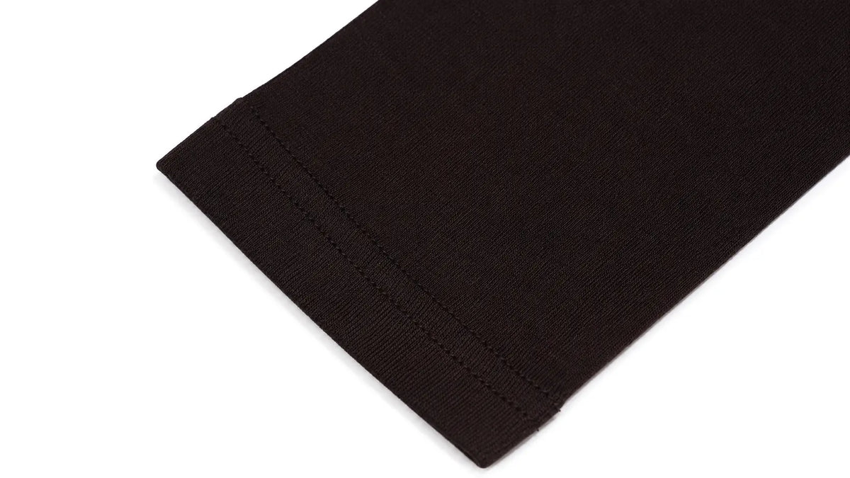 Close-up of a dark brown ribbed knit fabric cuff, showing the texture and hem stitching, on a plain white background. TCH Techno Butterfly Starburst Graphic Long Sleeve Top