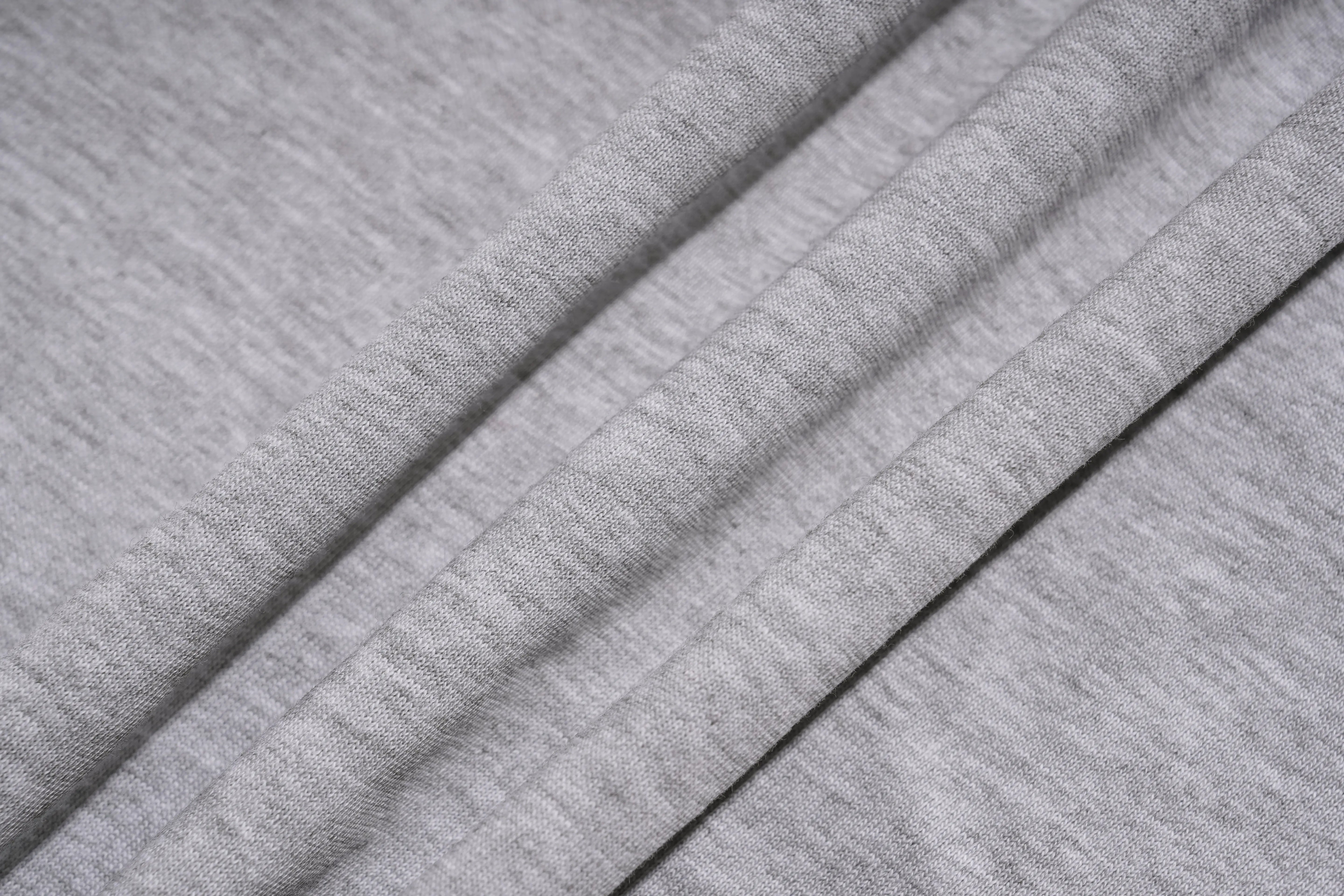 Close-up of light heather gray fabric with soft diagonal folds showing the knit texture. TCH Techno House Abstract Graphic Oversized T-Shirt