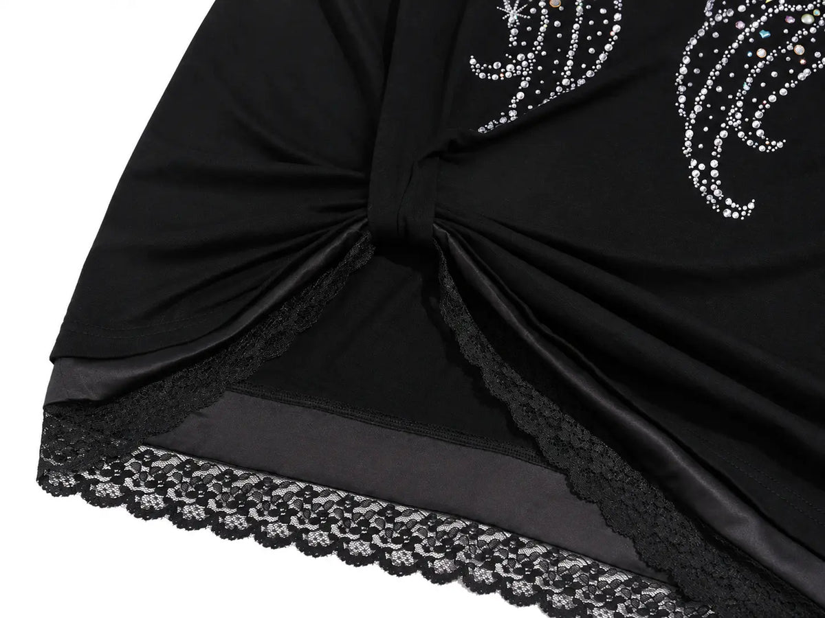 Close-up of a black draped garment or fabric accessory with a twisted knot detail, silver rhinestone embellishments, and a scalloped black lace hem on a white background. TCH Techno Rhinestone Angel Wings Lace Trim Off-Shoulder Top