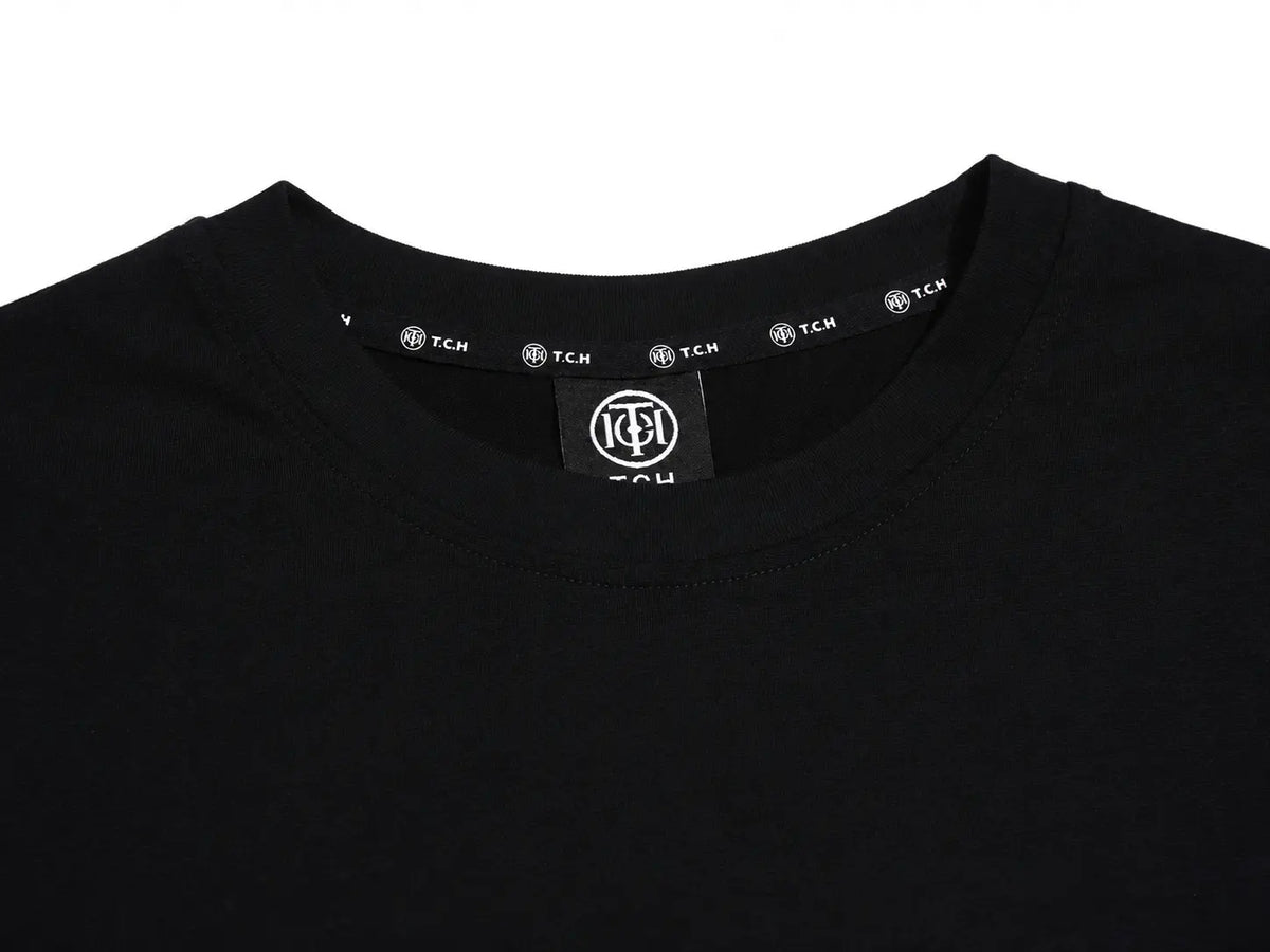 Close-up of a black crewneck t-shirt showing the inner neck label with a circular 'TCH' logo and repeated brand names along the inner collar. TCH Techno Rhinestone Gothic Graphic Black T-Shirt