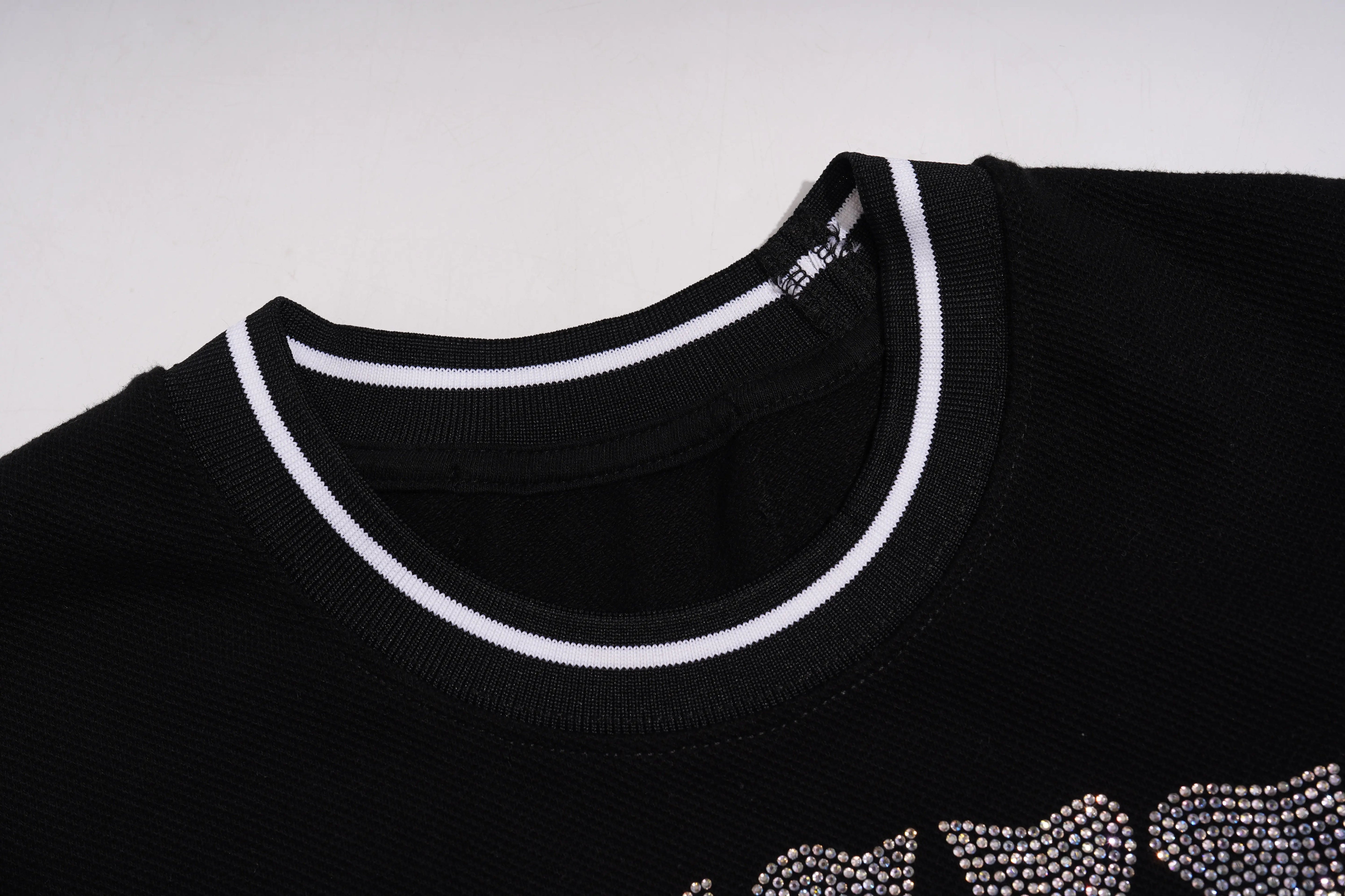 Black sweater with white trim and rhinestone details on a light gray background, TCH Techno Teddy Rhinestone T-Shirt