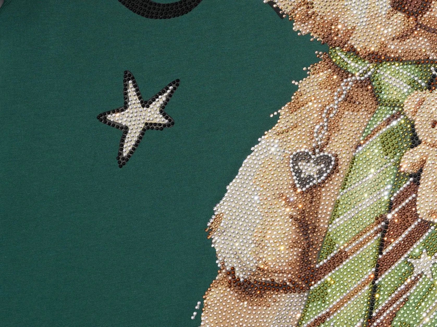 Close-up of a dark green fabric featuring a beaded cross-stitch or diamond painting design of a teddy bear wearing a green striped shirt and a heart-shaped brooch. TCH Teddy Bear Rhinestone Graphic T-Shirt
