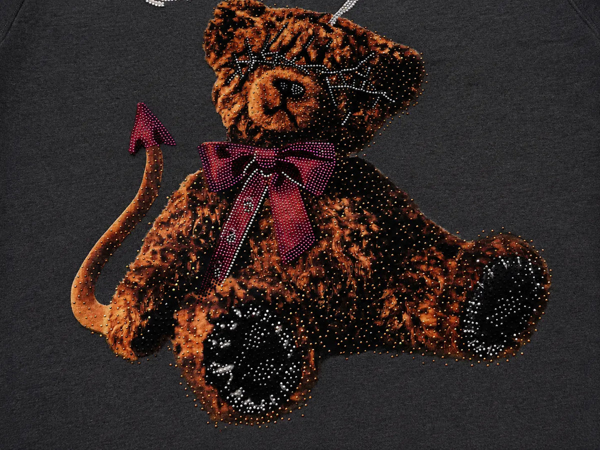 A close-up of a dark gray t-shirt featuring a rhinestone-embellished brown teddy bear with a red bow, devil horns, and a tail. TCH Vintage Teddy Bear Graphic Sweatshirt