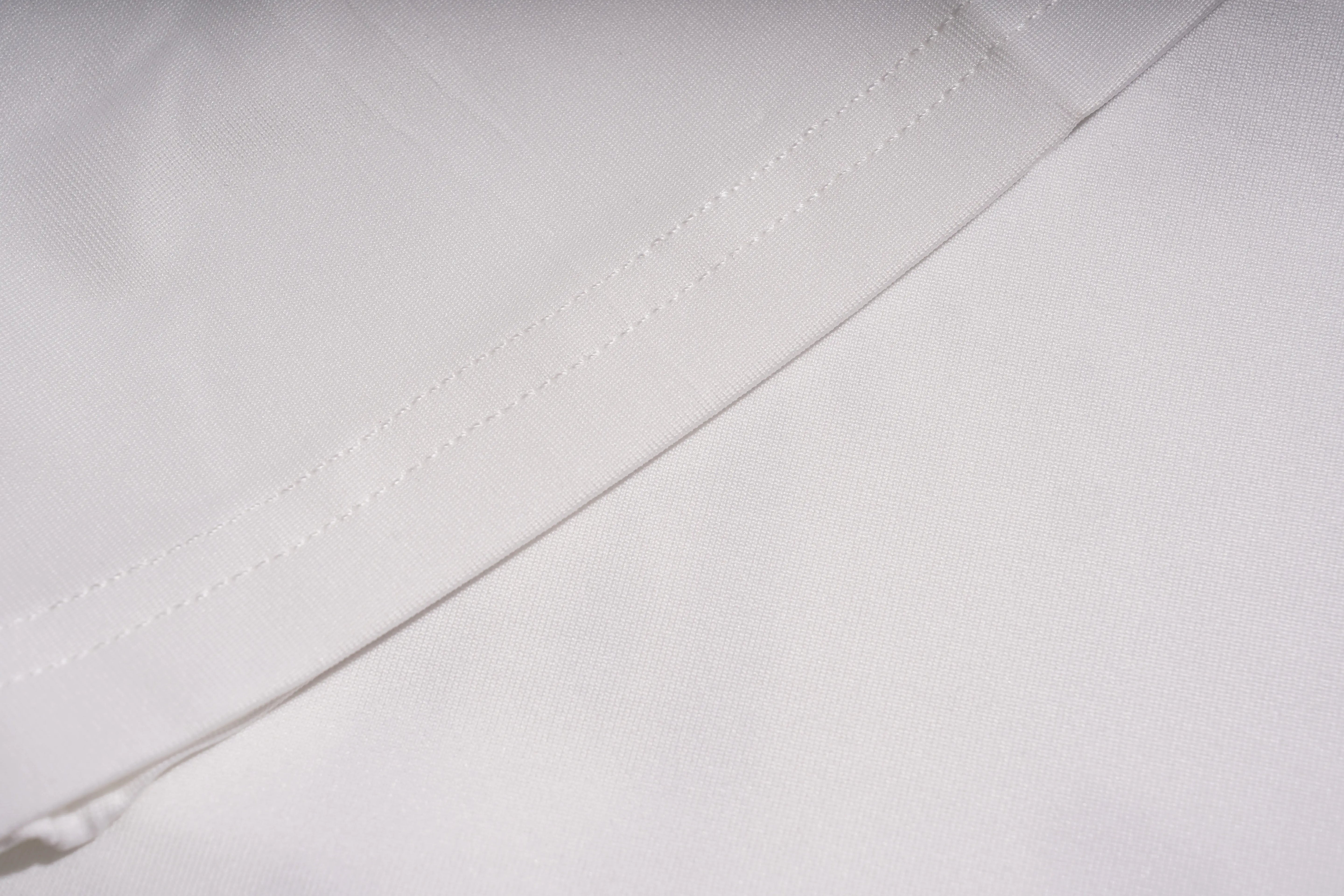 Close-up of a white fabric with a subtle pattern, TCH White Lace Trim V-Neck Rhinestone Wing Long Sleeve Top