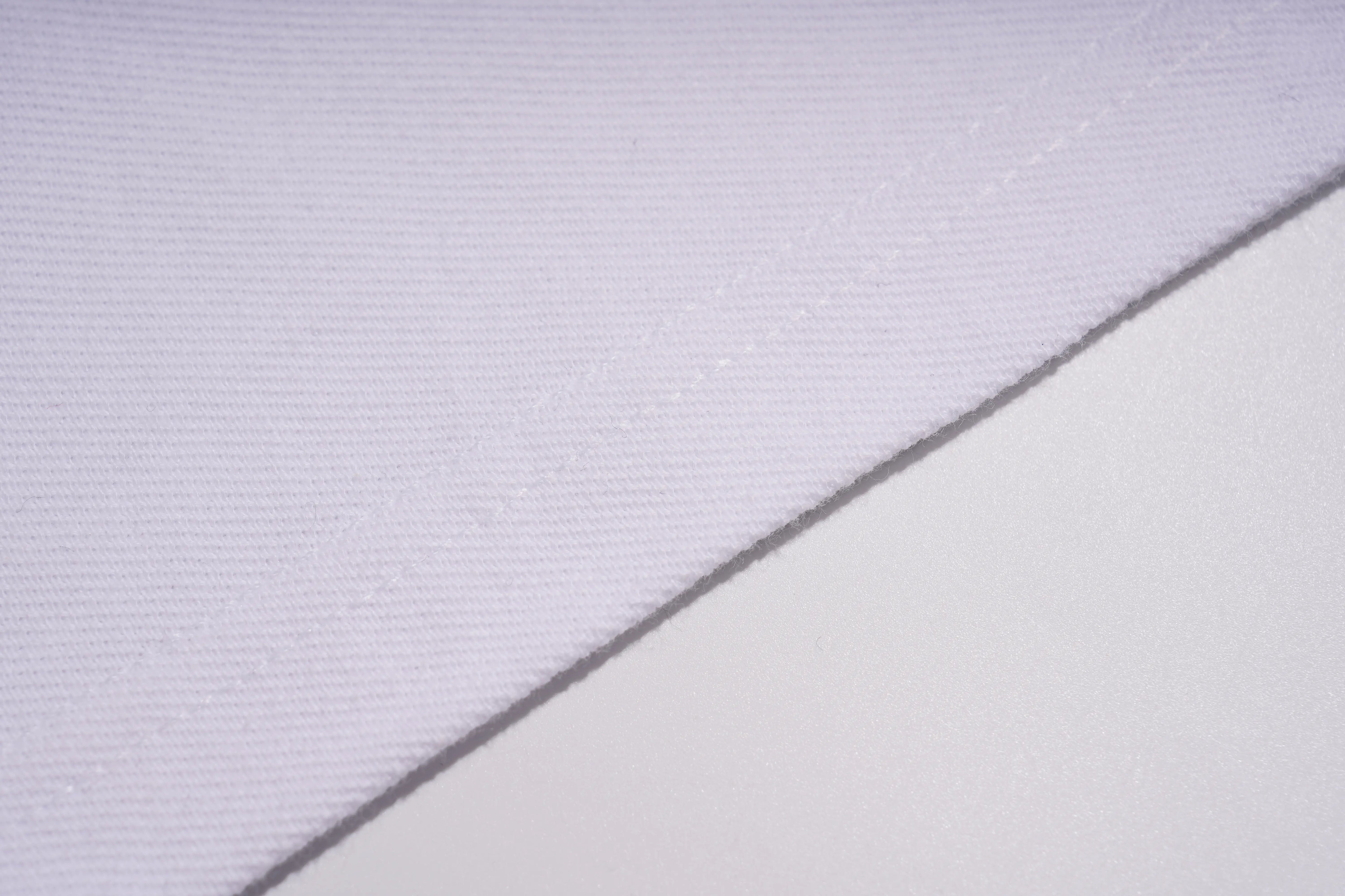 A close-up of a white woven fabric with a diagonal seam dividing it into two sections. TCH White Teddy Bear Embellished Polo Shirt