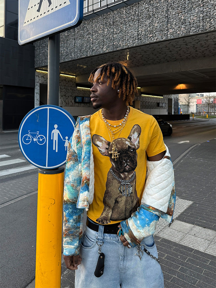 A person wearing a yellow short sleeve T-shirt with a dog graphic print, round neckline, and regular fit.