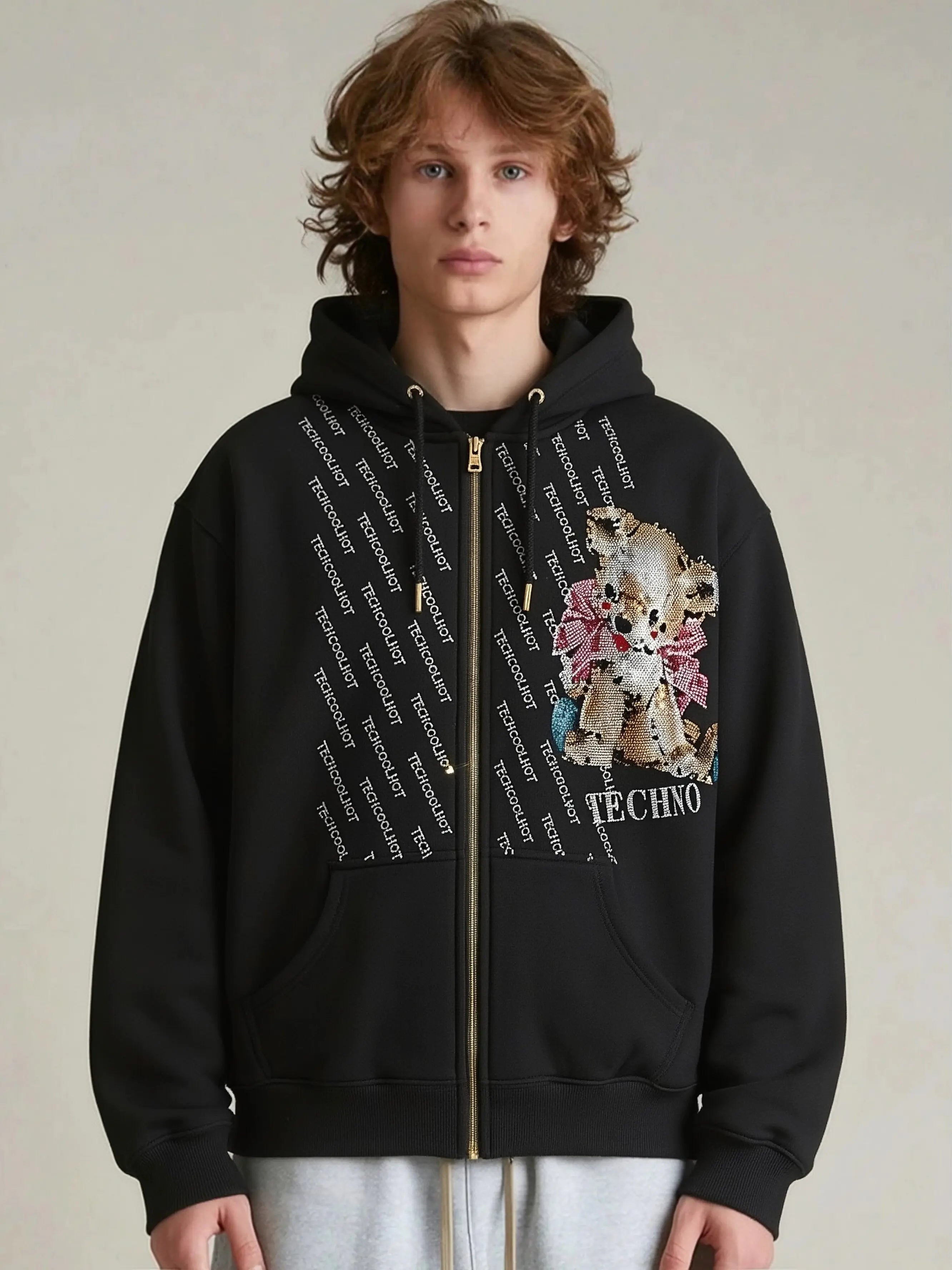 Person wearing a black hoodie with a floral design and text on a neutral background, Rhinestone Bear “TECHNO” Zip-Up Hoodie