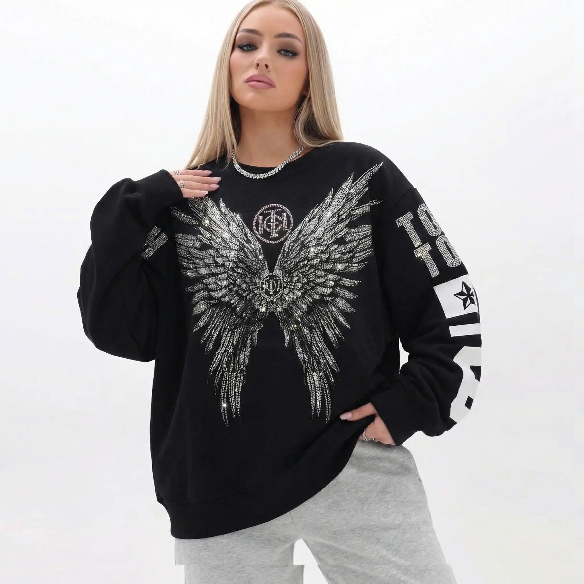 Woman wearing a black sweatshirt with an eagle design and text on a white background, TCH 1976 Rhinestone Wings Sweatshirt