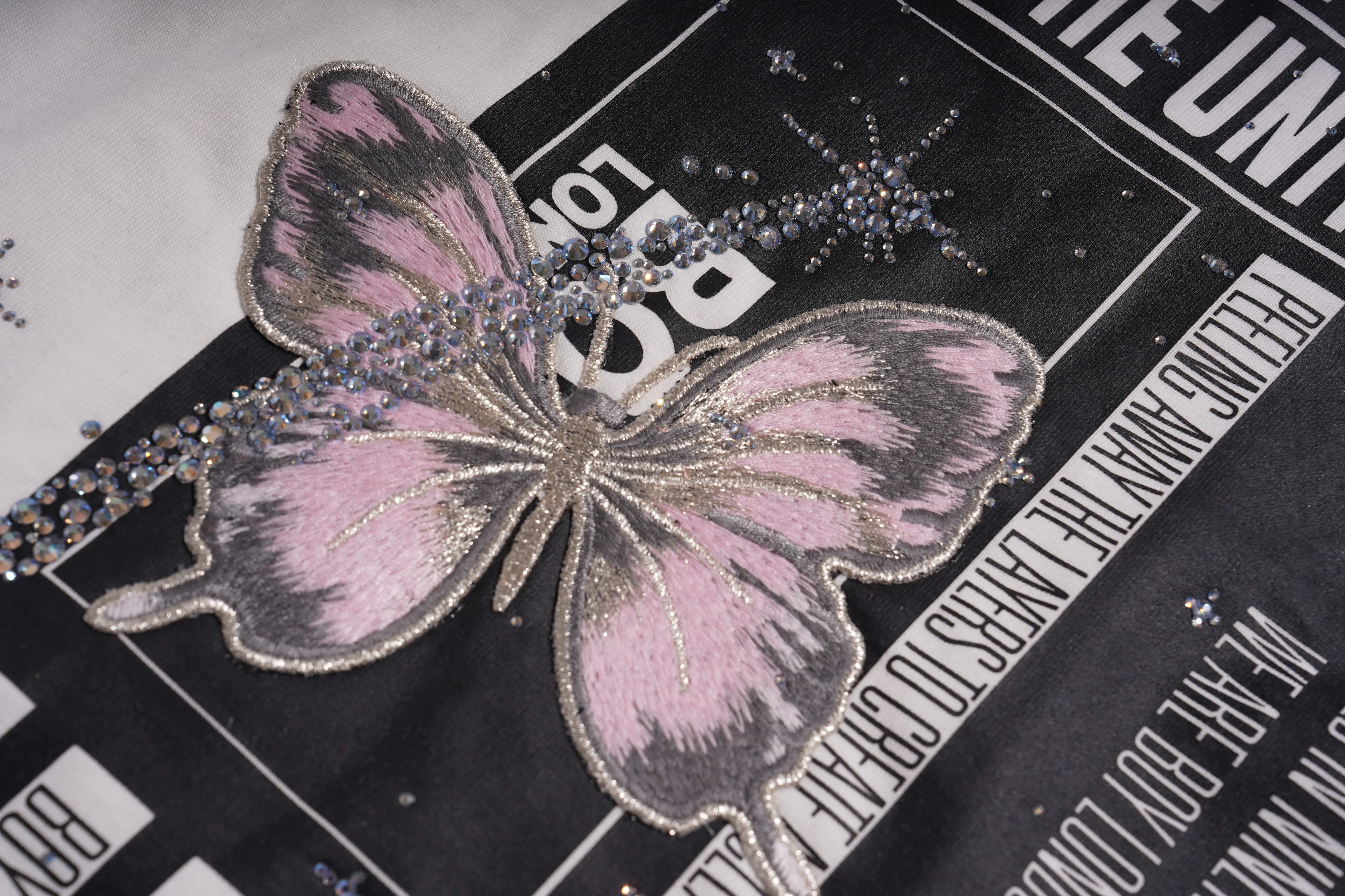 Pink butterfly with rhinestone accents on a black background with text, TCH Anarchy Graphic Rhinestone T-Shirt