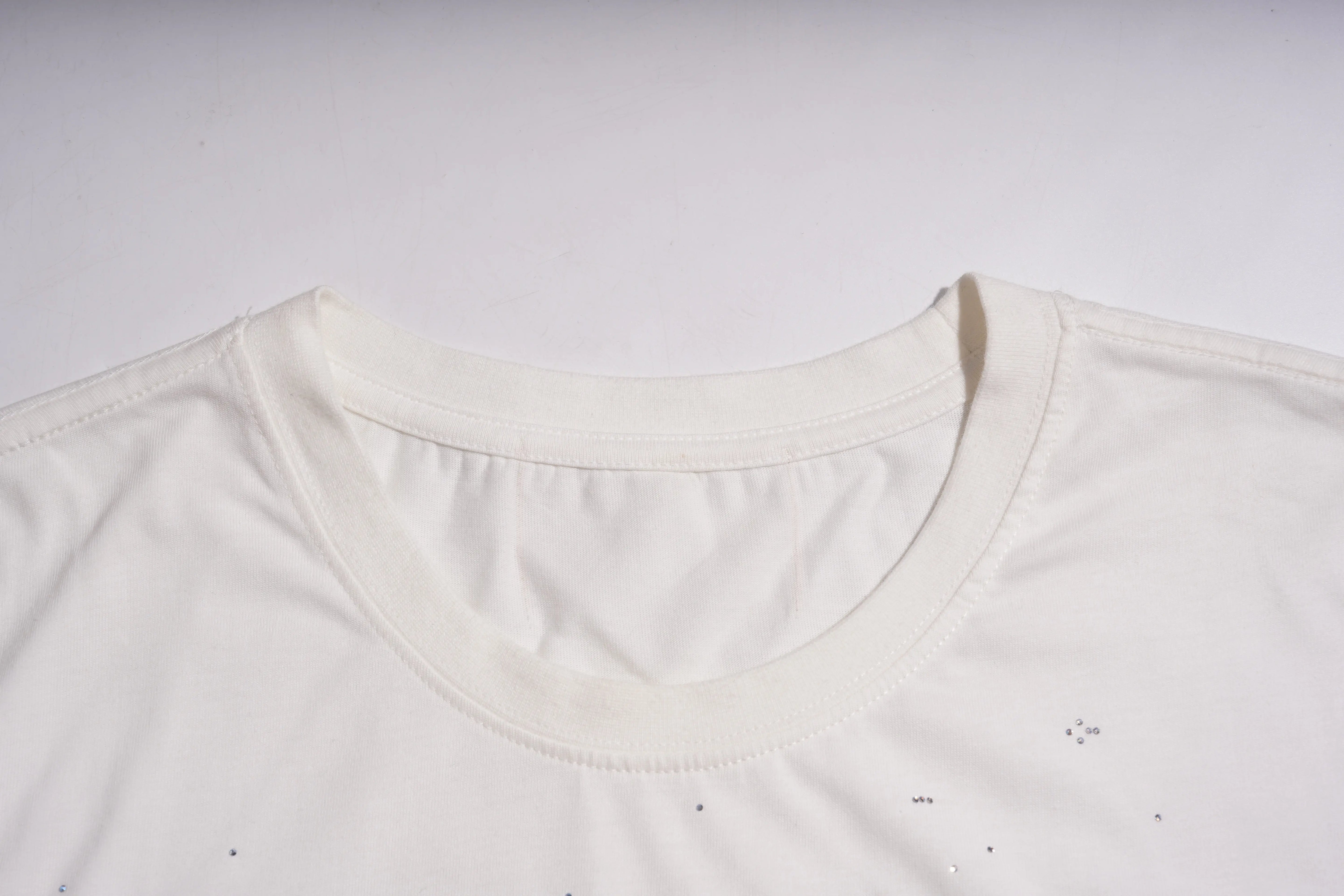 Close-up of a white shirt collar on a light gray background, TCH Anarchy Graphic Rhinestone T-Shirt