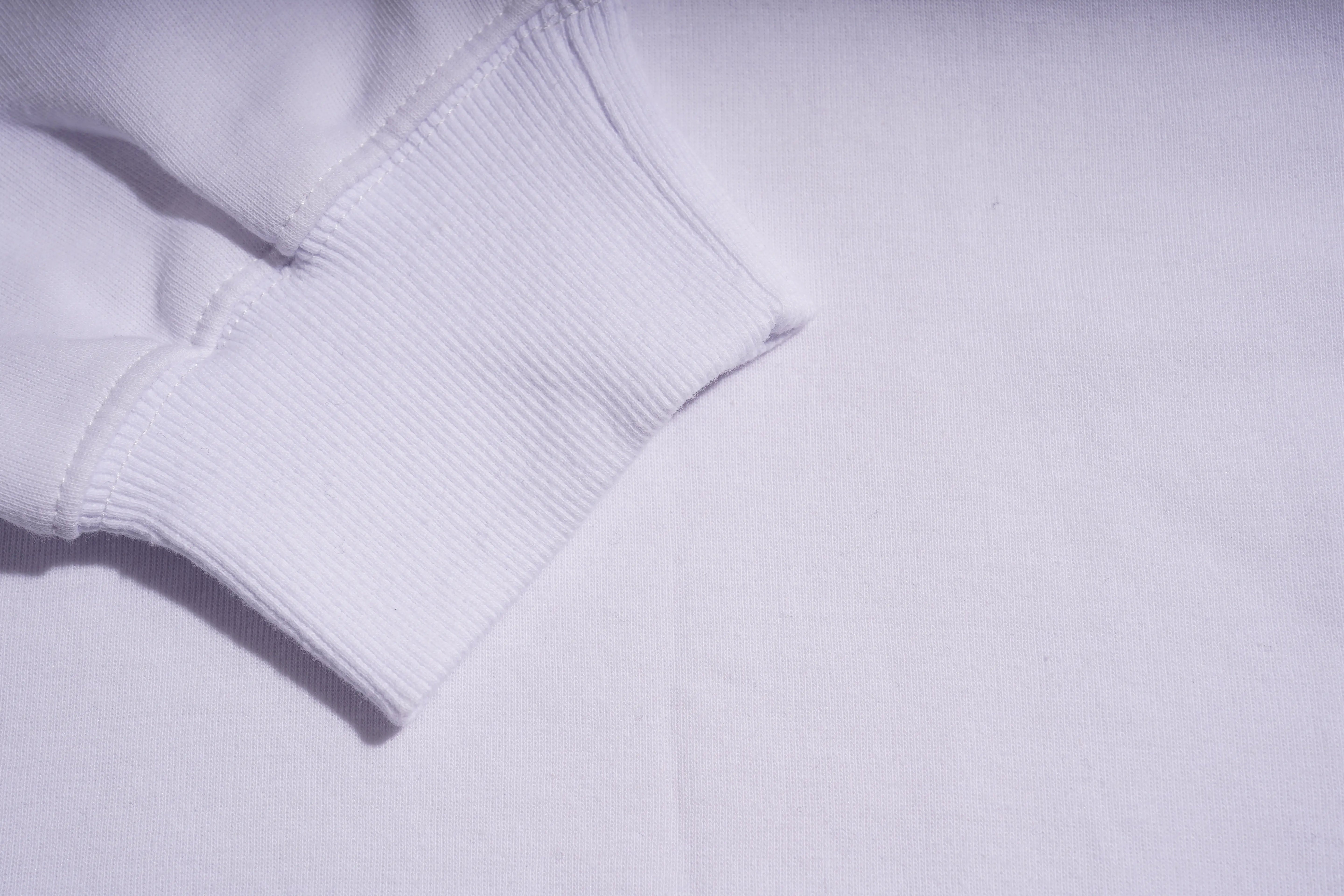Close-up of a light gray sweater sleeve on a matching background