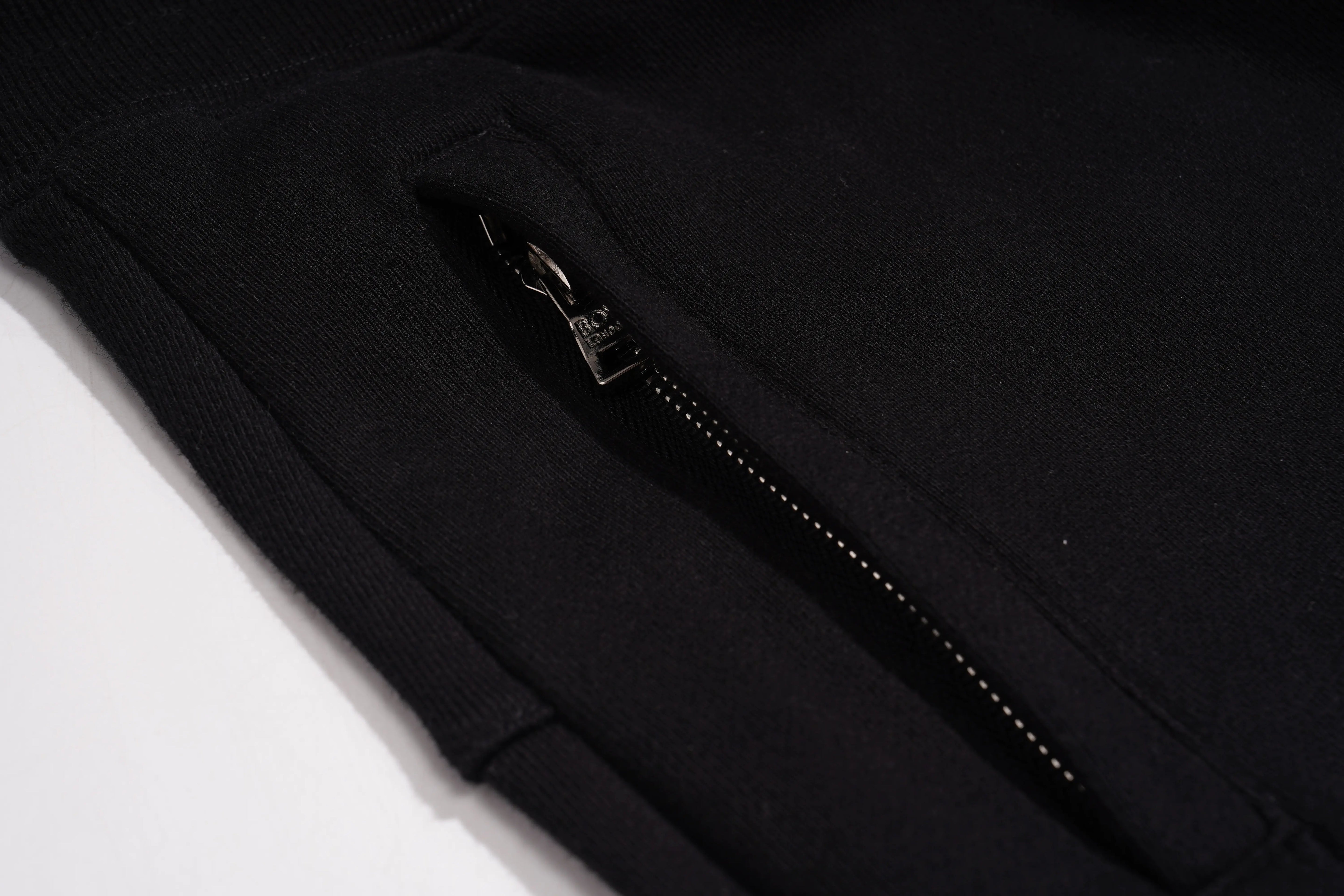 Close-up of a black zipper on a dark fabric background, TCH Bear Sketch Rhinestone Jogger Pants