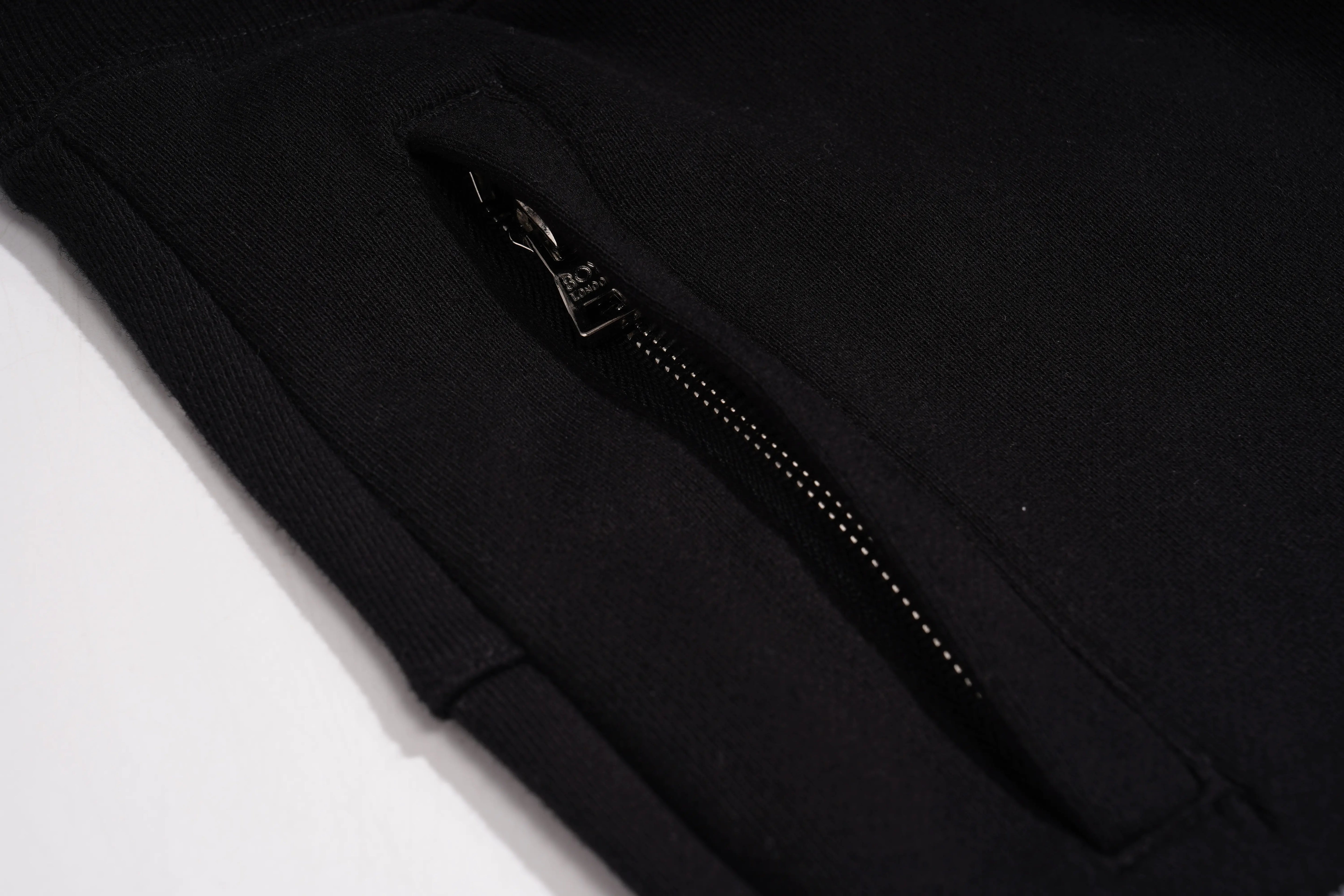 Close-up of a black jacket with a zipper on a white background, TCH Bear Sketch Rhinestone Jogger Pants
