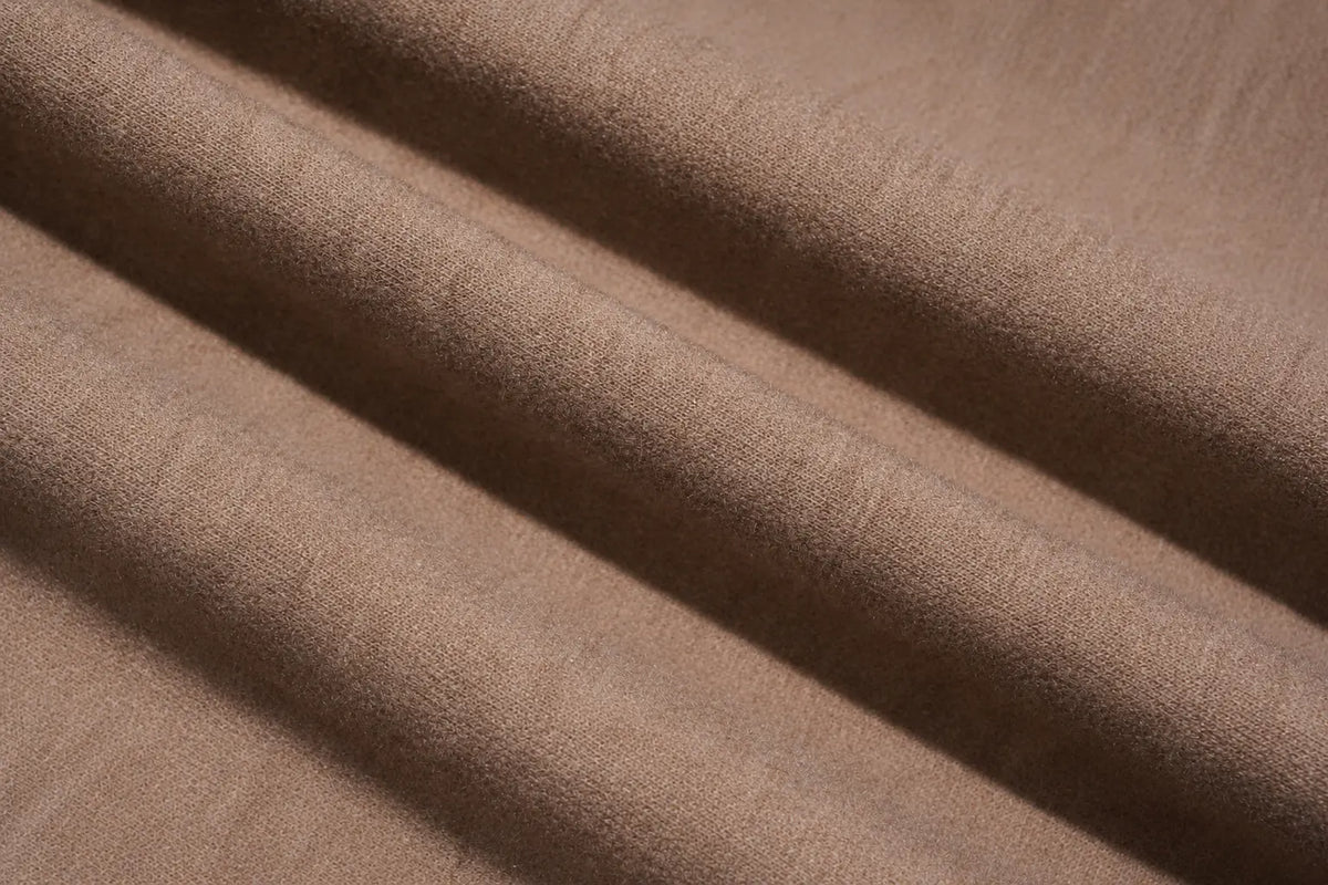 A close-up of draped brown fabric with soft folds and a subtle woven texture. TCH Beige Teddy Bear Rhinestone Layered Hoodie Sweatshirt