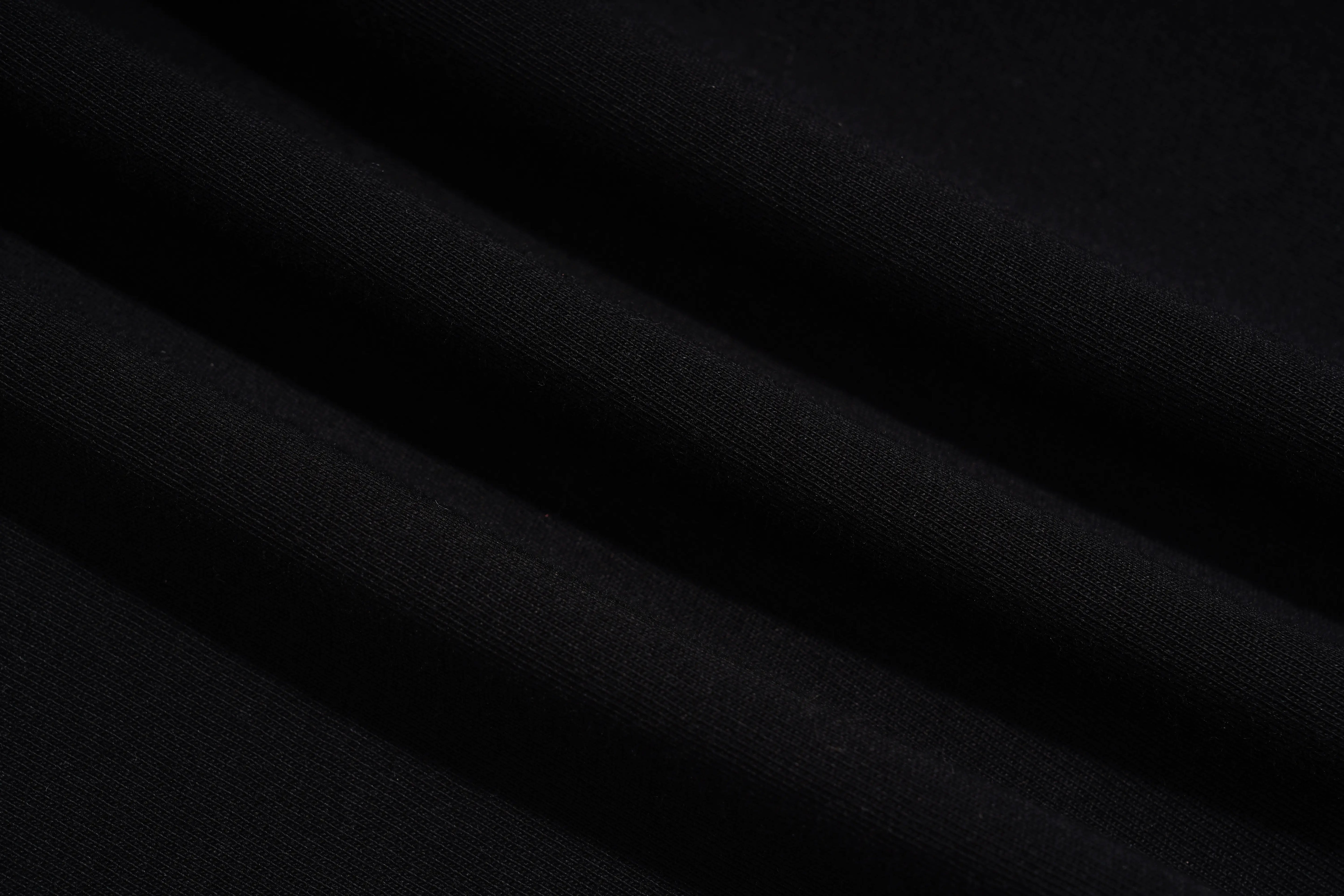 A close-up of draped black fabric with soft folds showing a fine knit texture. TCH Black Rhinestone Corset Graphic T-Shirt