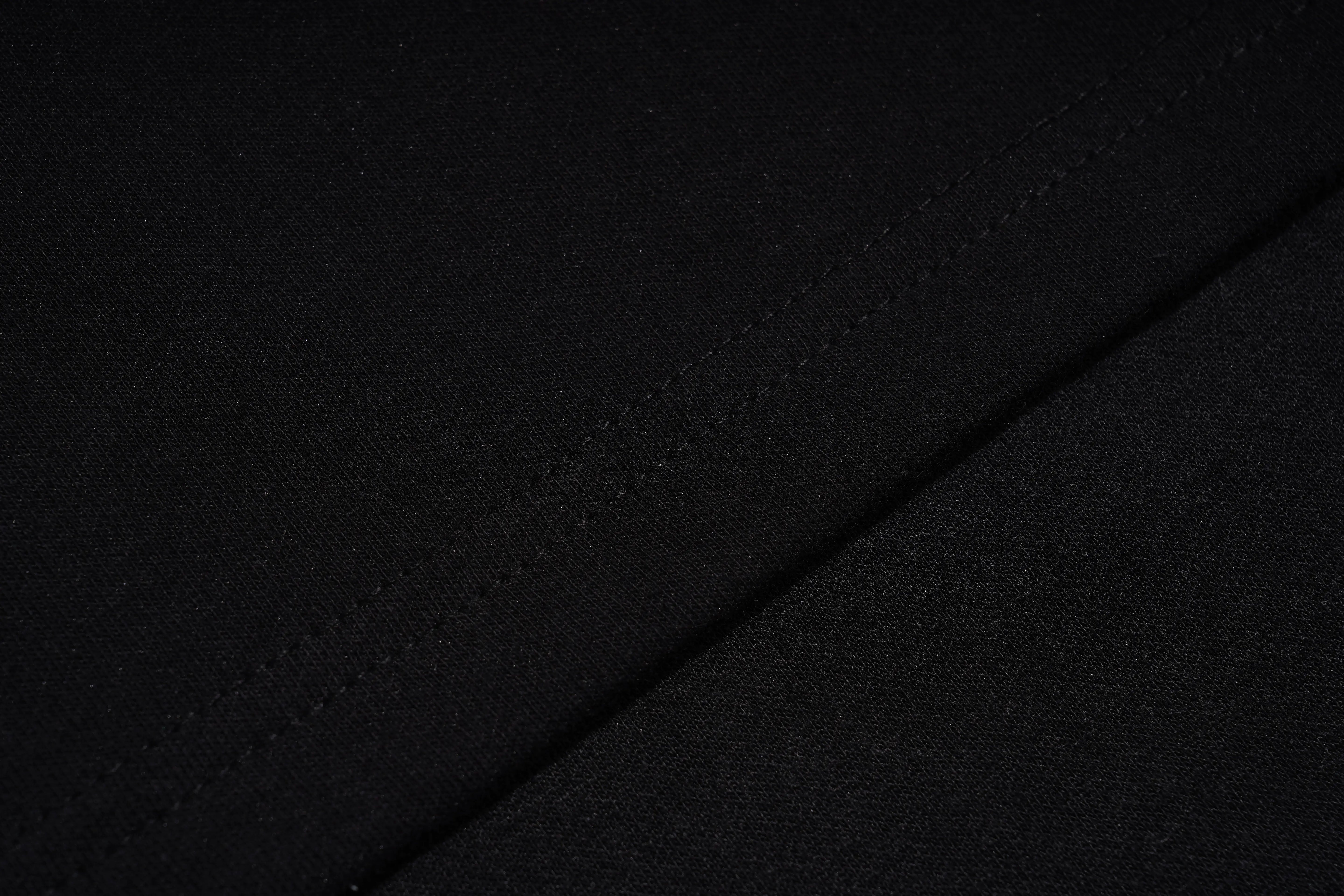 Close-up of black fabric with a diagonal seam and fine woven texture. TCH Black Rhinestone Fringe Detail Long Sleeve Mini Dress