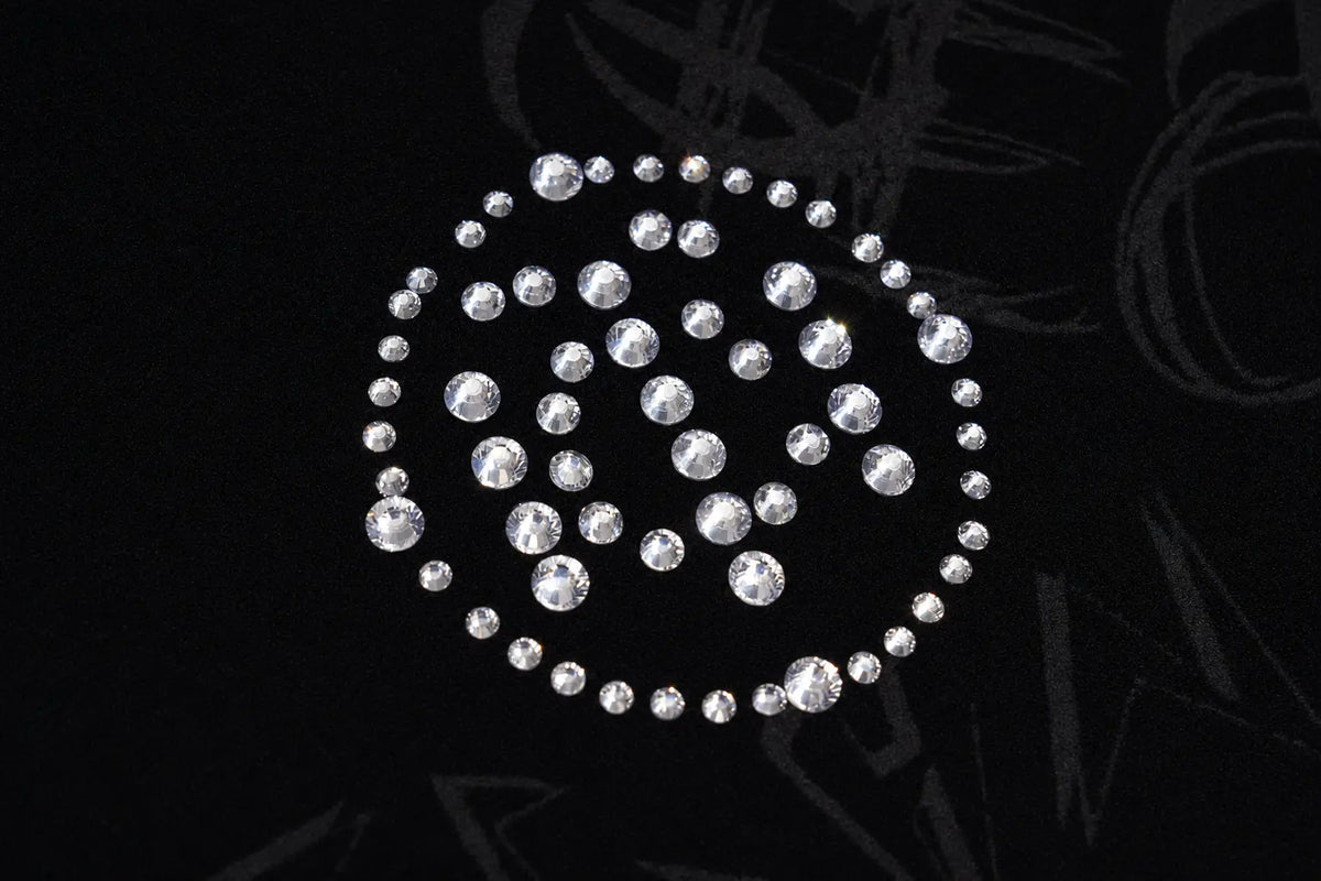 A circular arrangement of clear rhinestones or gemstones on a black background. TCH Black Rhinestone Monogram Zip Up Hoodie Jacket