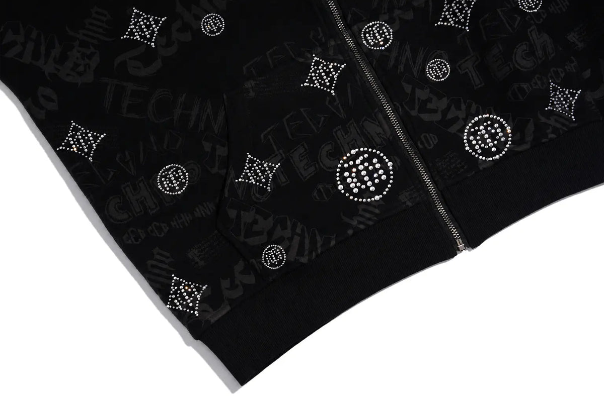 Close-up of a black zip-up jacket featuring an all-over dark gray graffiti-style graphic print and silver rhinestone-embellished monogram motifs. TCH Black Rhinestone Monogram Zip Up Hoodie Jacket