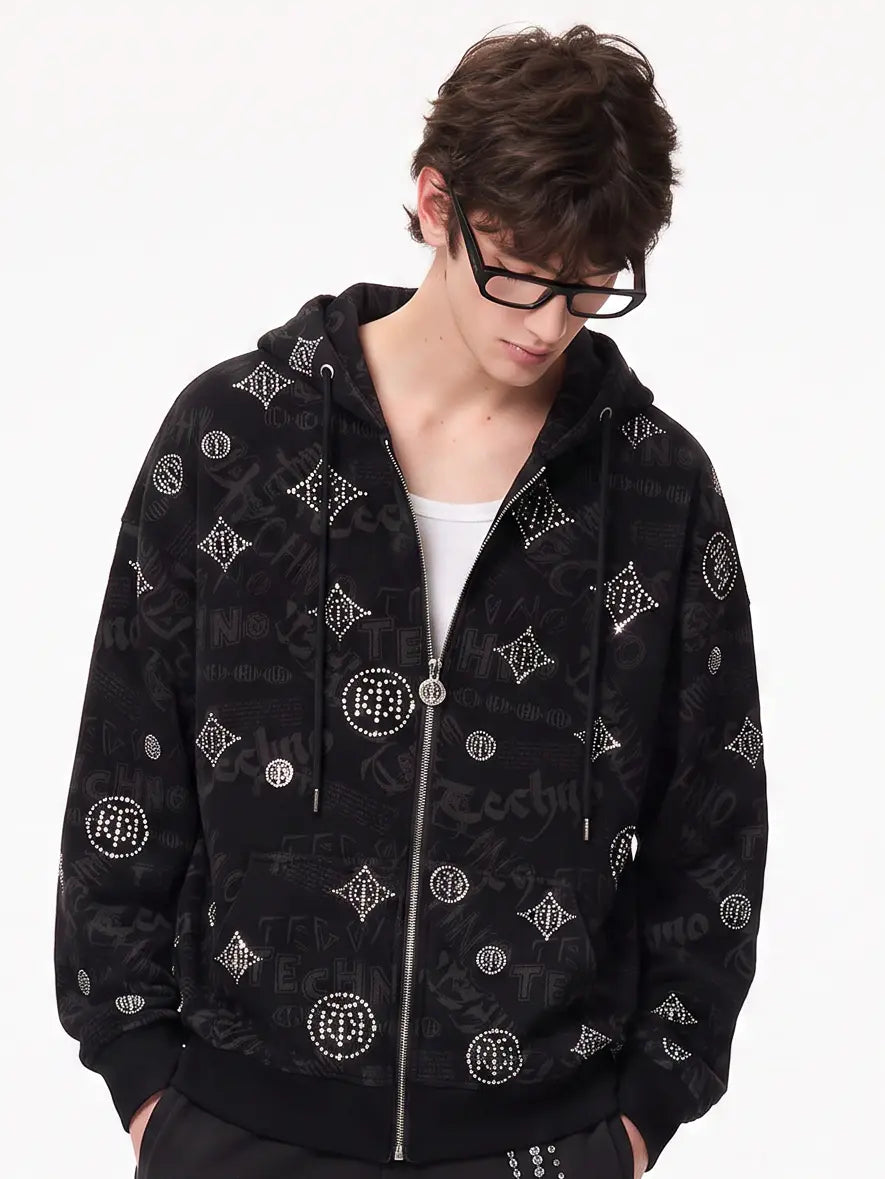 A model wearing a light blue denim jacket with various embroidered patches, including a teddy bear on the left chest and cherries on the sleeve, styled over a white t-shirt and dark pants. TCH Black Rhinestone Monogram Zip Up Hoodie Jacket