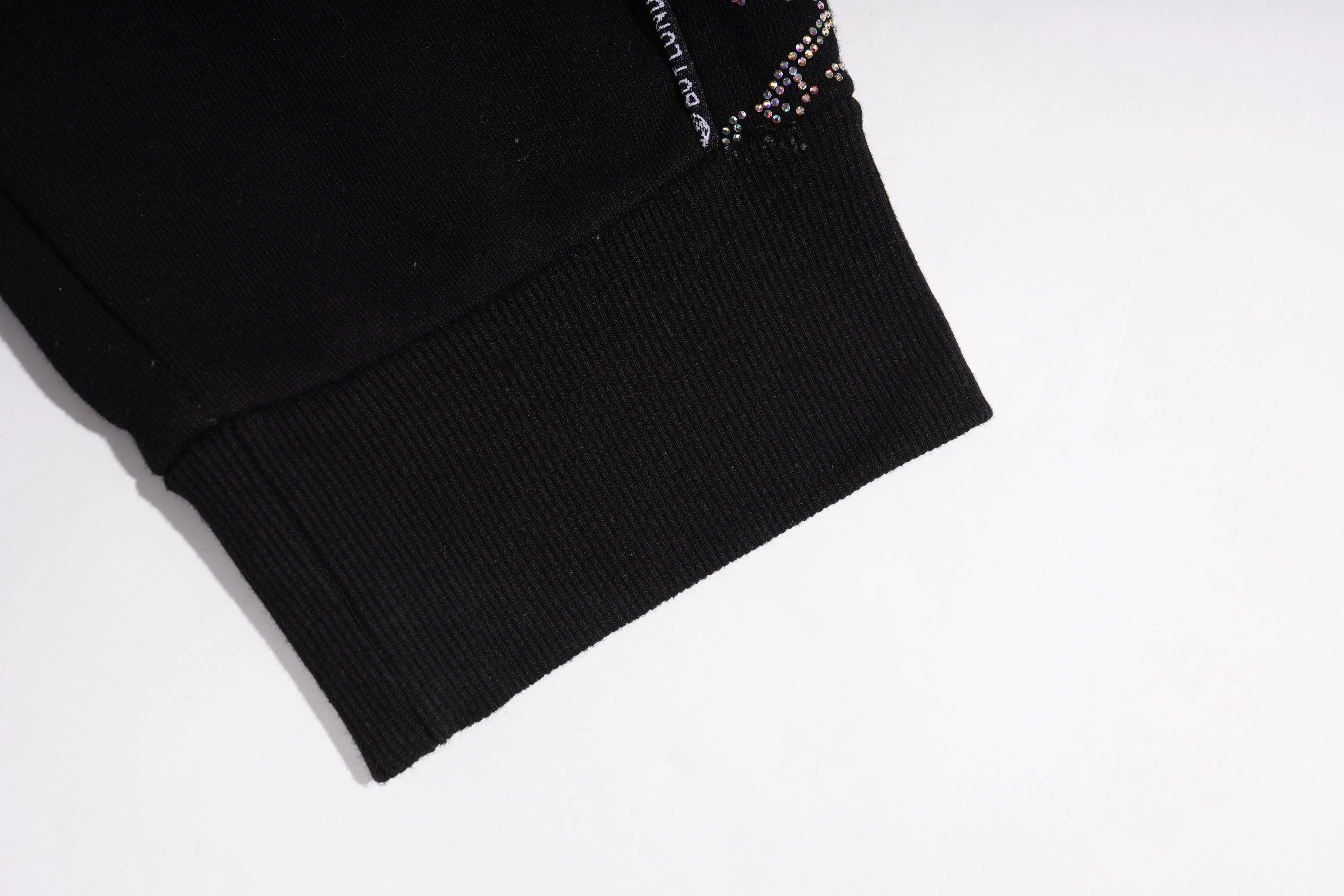 Black ribbed knit fabric with a brand label on a white background, TCH Black Rhinestone Side Stripe Jogger Pants