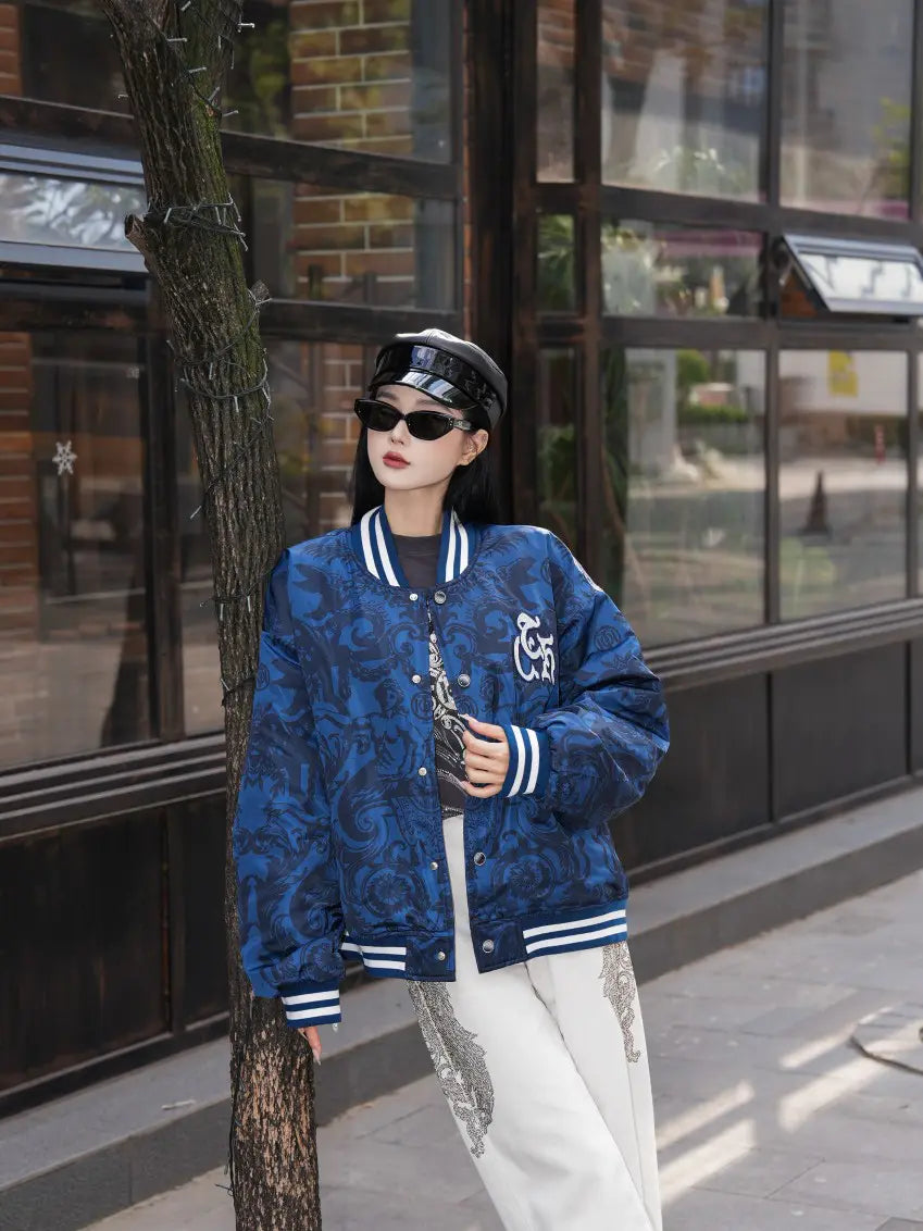 TCH Blue Baroque Pattern Embroidered Varsity Jacket TCH blue varsity jacket Blue baroque pattern jacket Gothic graphic varsity jacket Navy blue streetwear jacket Baroque print bomber jacket Embroidered varsity jacket Gothic lettering jacket Blue snap-button jacket Ornamental print streetwear jacket TCH graphic bomber jacket