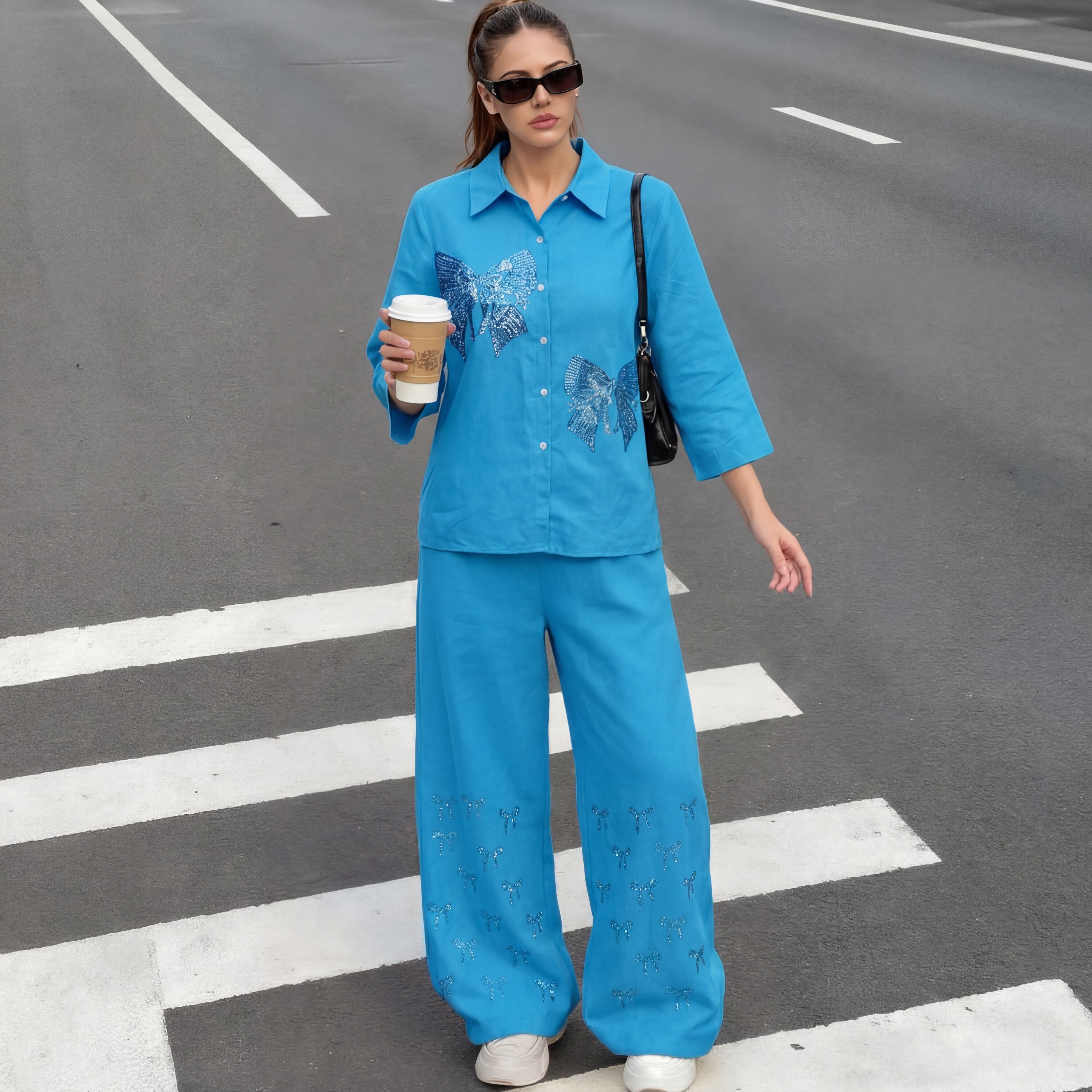 Woman in a blue outfit with floral patterns crossing a street. TCH Blue Rhinestone Bow Matching Set