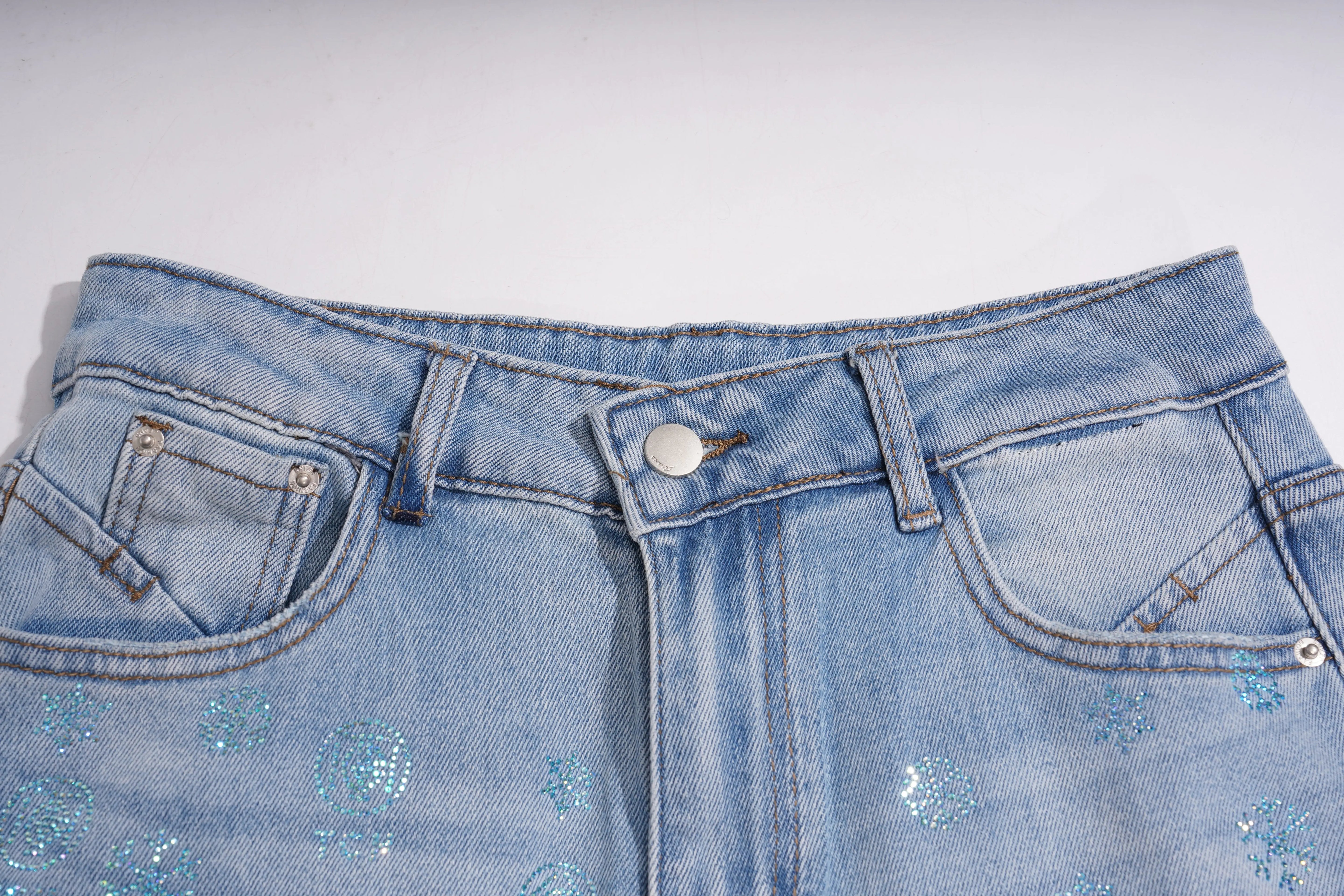 Close-up of blue jeans with decorative elements on a white background, TCH Blue Snowflake Rhinestone Denim Jeans